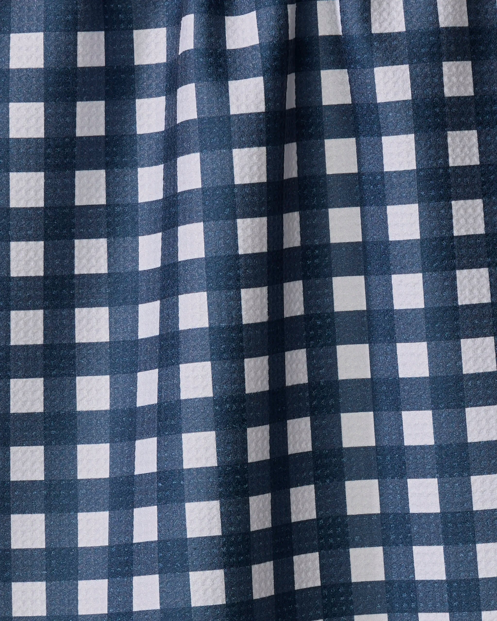 Close-up of The Buy Guide's Gigi - Navy tea towel, featuring a blue and white checkered pattern with textured surface, evenly spaced squares, and subtle folds.