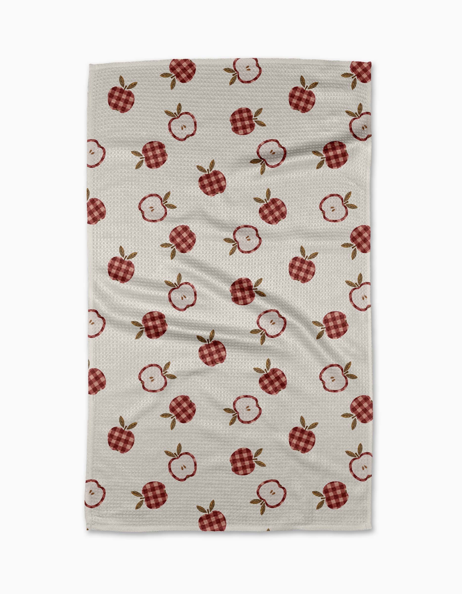 The Gingham Apples tea towel by Teri the Butter features a cream base with red apples, red gingham apples, and green leaves scattered evenly across the fabric.