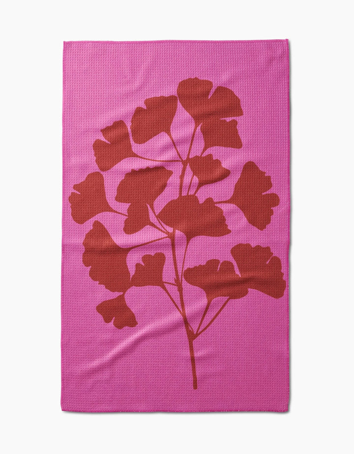 PrintedPlant’s Ginkgo blanket is pink and rectangular, with a bold red leafy branch silhouette in the center, made from ultra-absorbent Geoweave fabric for exceptional softness and durability.