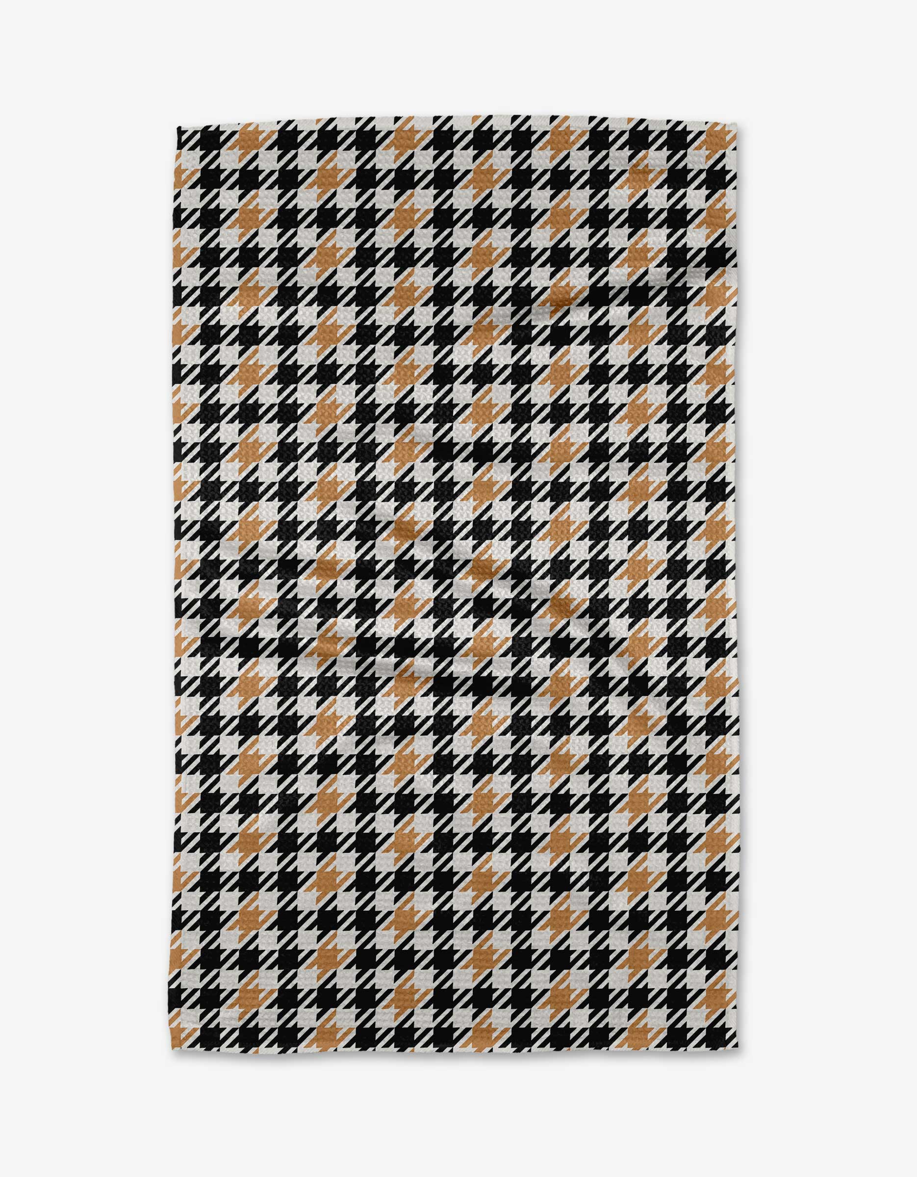 The “Golden Houndstooth” tea towel by Hufton Studio features a classic black, white, and tan houndstooth print in a repeating grid—a bold geometric design to elevate your kitchen decor.