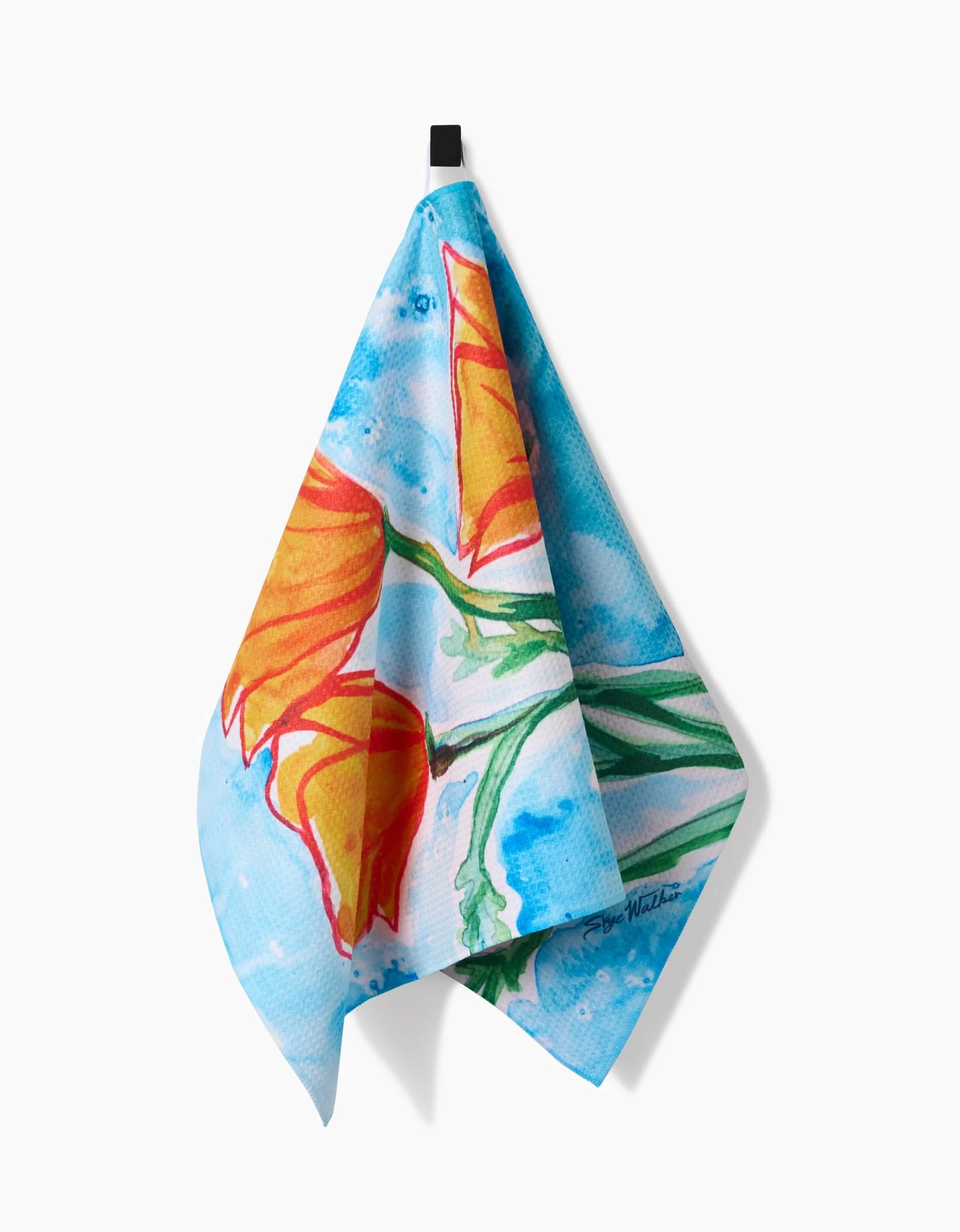 The Golden Poppy Flowers tea towel by Skye Walker features orange California poppies with green stems on a blue watercolor-style Geoweave™ fabric and hangs from a black loop.