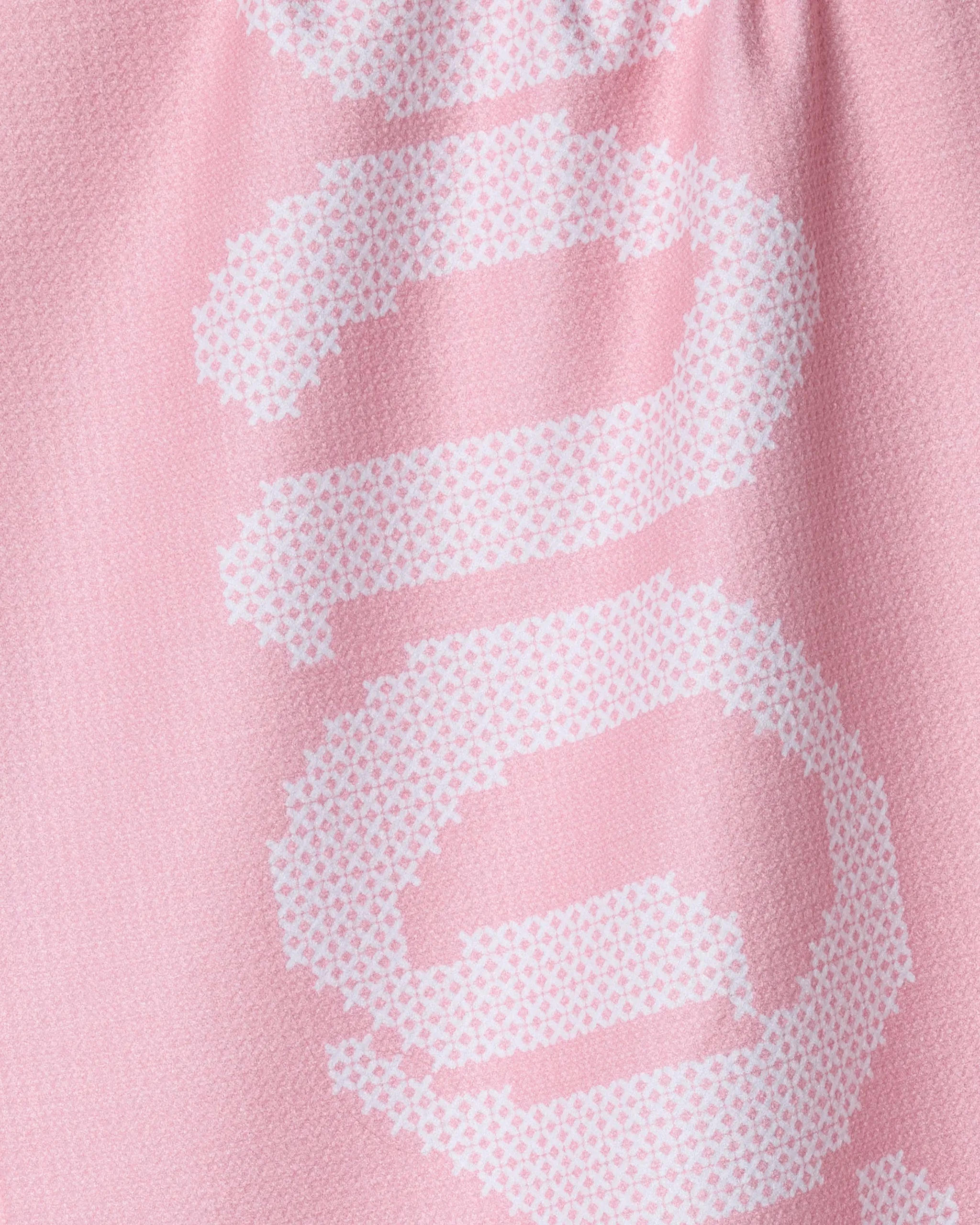 Close-up of Geometry's Grand Love pink tea towel, made from recycled materials, showcases a white pixelated abstract swirl. The image highlights the fabric’s texture and quick-drying quality.