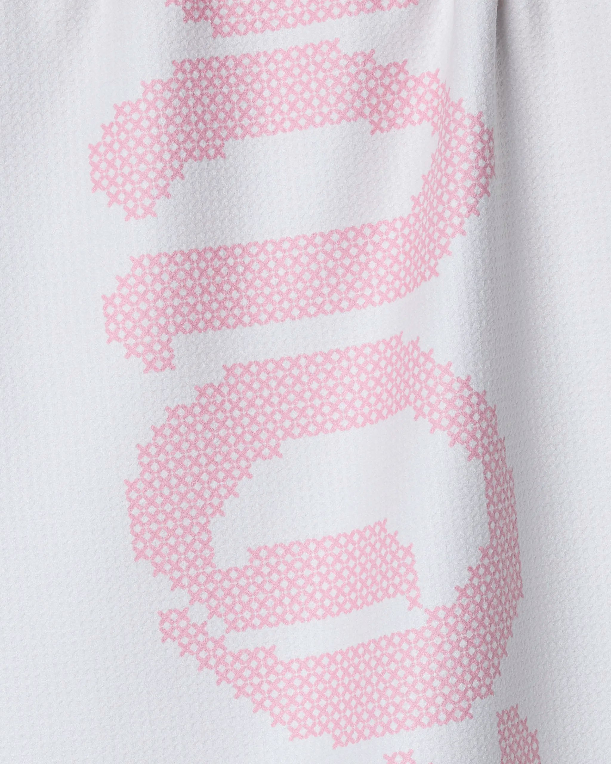 Close-up of Geometry's Grand Love White kitchen towel, featuring a large pixelated pink design on white fabric with a textured pattern and subtle folds.
