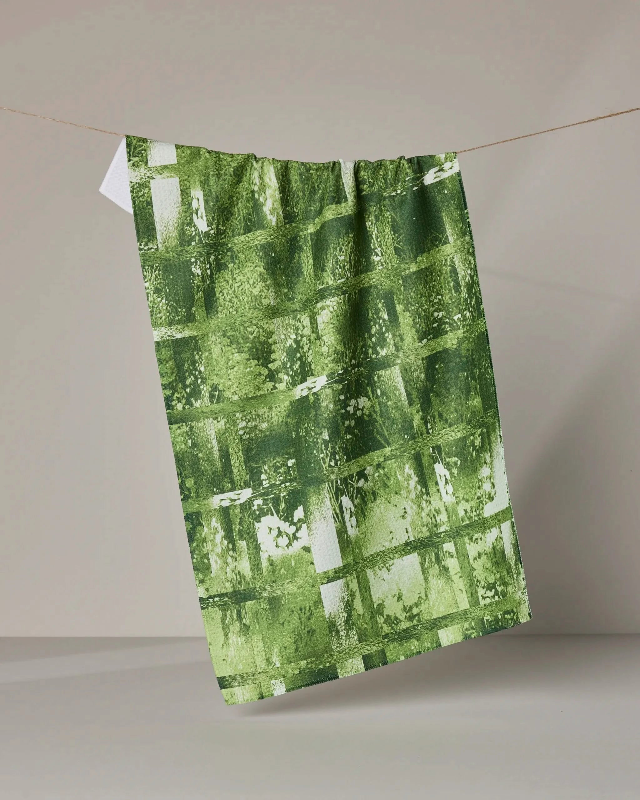 The Geometry Greenhouse tea towel hangs on a rope, offering ultra-absorbency—perfect for eco-friendly kitchens.