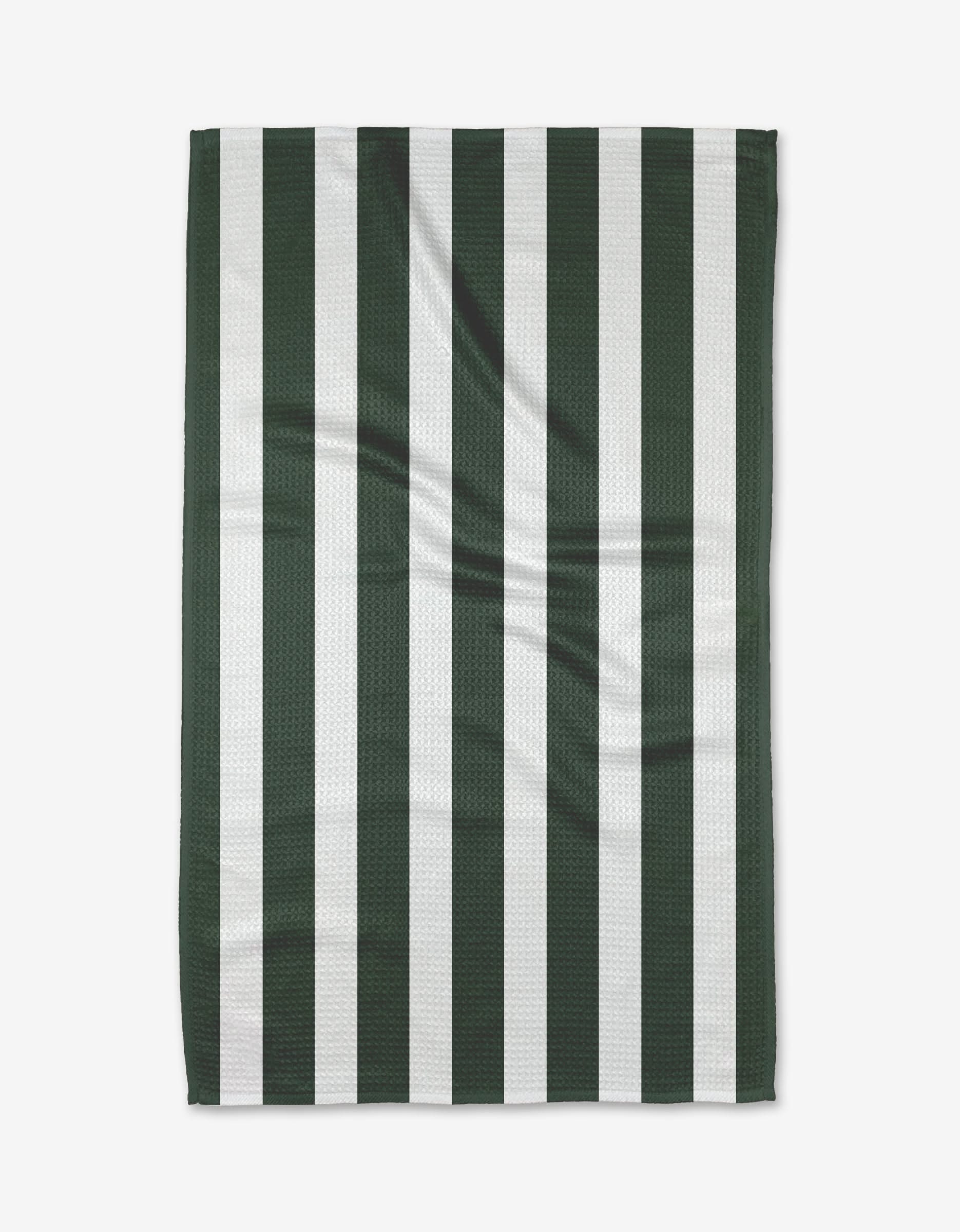 The Greens Tea Towel by BetterDays features vertical dark green and white stripes, is laid flat to show its textured Geoweave fabric with gentle creases, highlighting its durable construction.