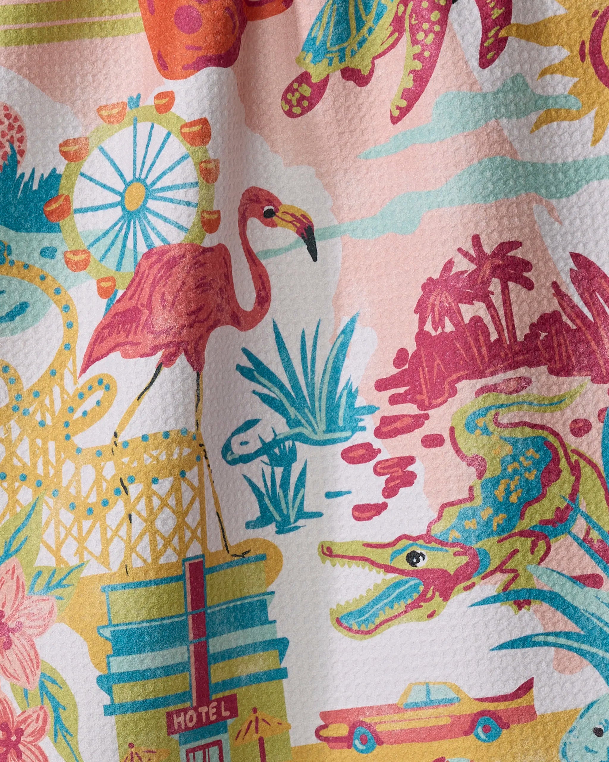 The "Greetings From Florida" kitchen towel by Geometry showcases a colorful, retro design with a ferris wheel, flamingo, palm trees, alligator, hotel, lily pads, and yellow car on soft recycled fabric.