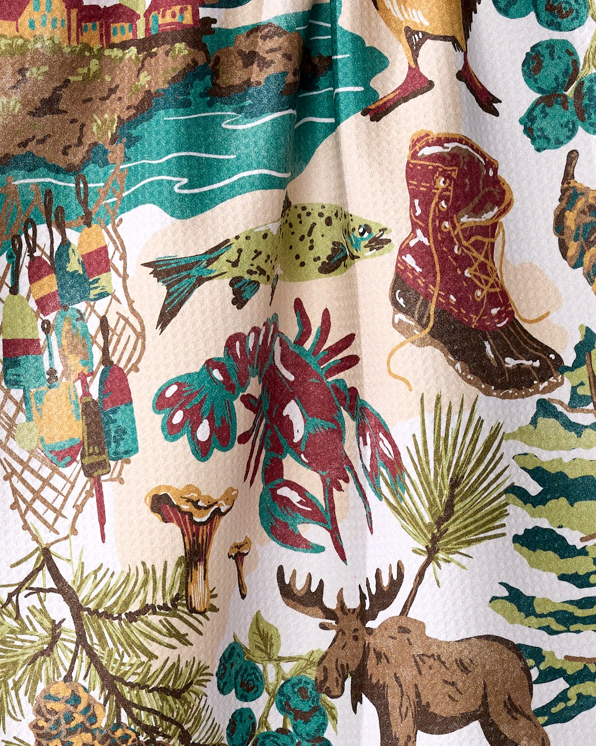 The Geometry "Greetings From Maine" tea towel features vintage, nature-themed illustrations of a lobster, moose, fish, pine branches, mushrooms, red boot, fishing buoys, and a lakeside village.
