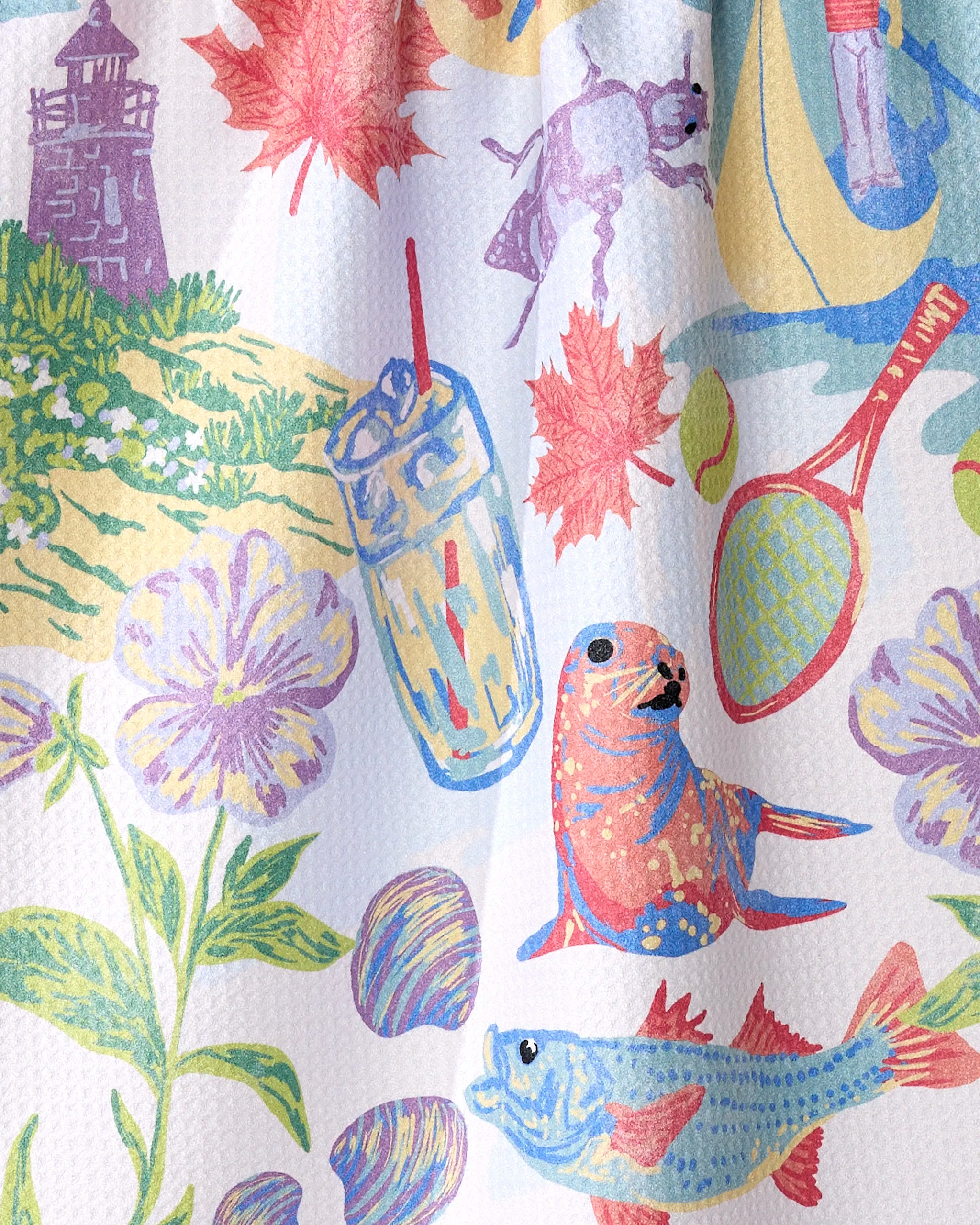 The Geometry "Greetings From Rhode Island" kitchen towel features colorful drawings of a lighthouse, canoe, flowers, and more on a white textured background—perfect for adding charm and absorbency to your kitchen.