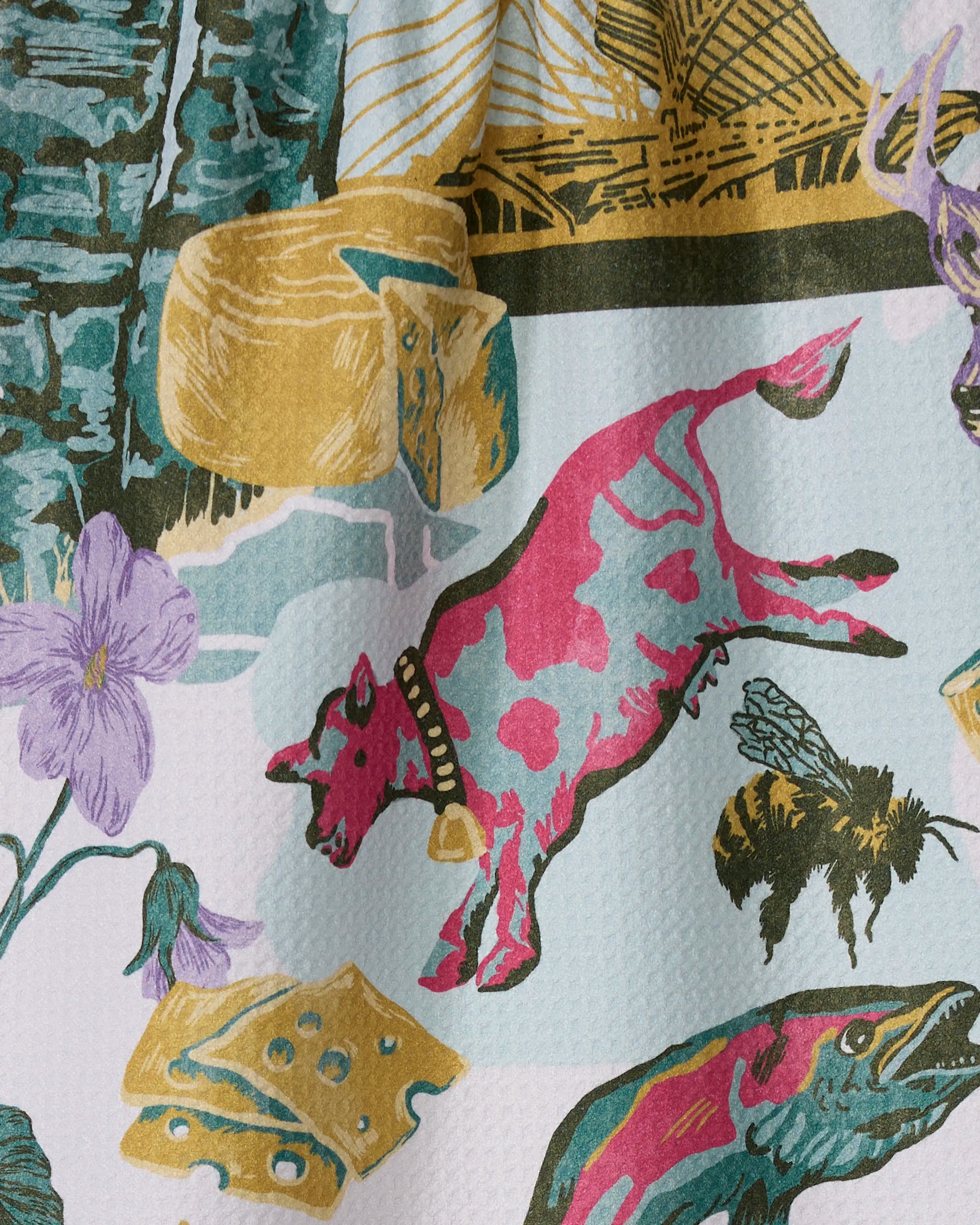 The "Greetings From Wisconsin" tea towel by Geometry features whimsical illustrations and is crafted from ultra-absorbent recycled materials for charm and practicality.