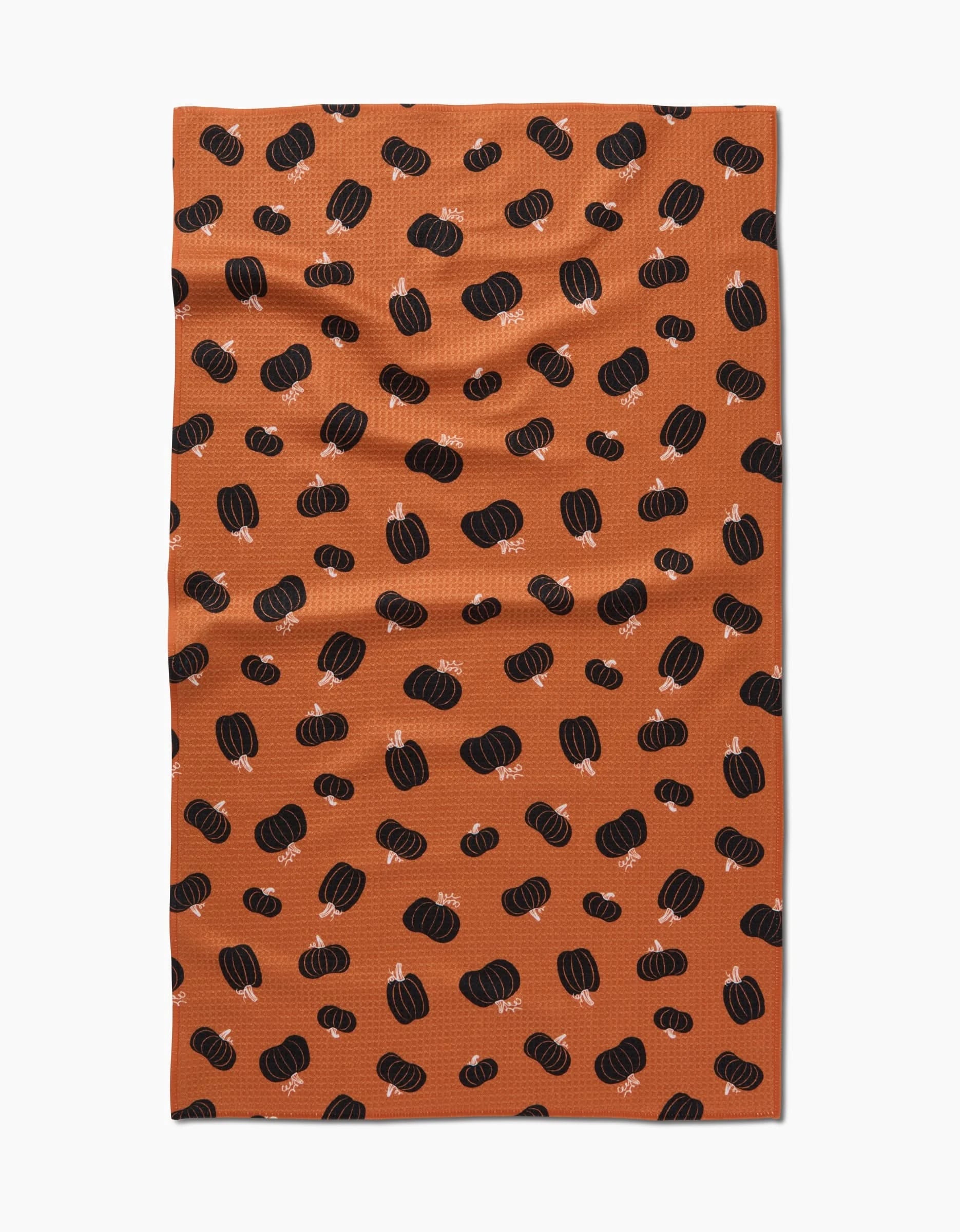 The Halloween Black Pumpkins tea towel by Hufton Studio features black and dark orange pumpkins on an orange background—an ultra-absorbent, festive touch for your kitchen.