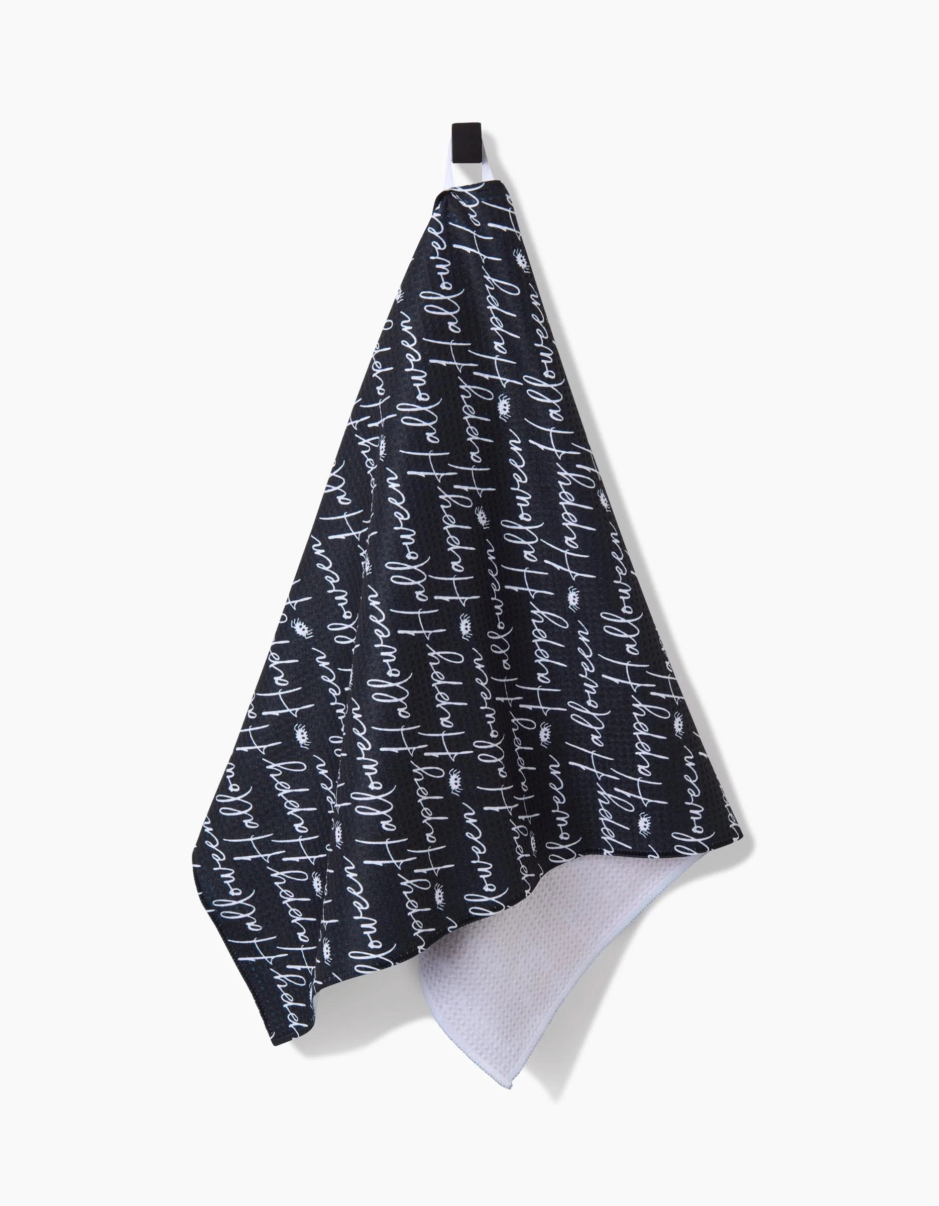 The Geometry Halloween Script Black towel is a dark ultra-absorbent towel with white cursive flowers always flowers text, shown hanging from a black loop on a white background.
