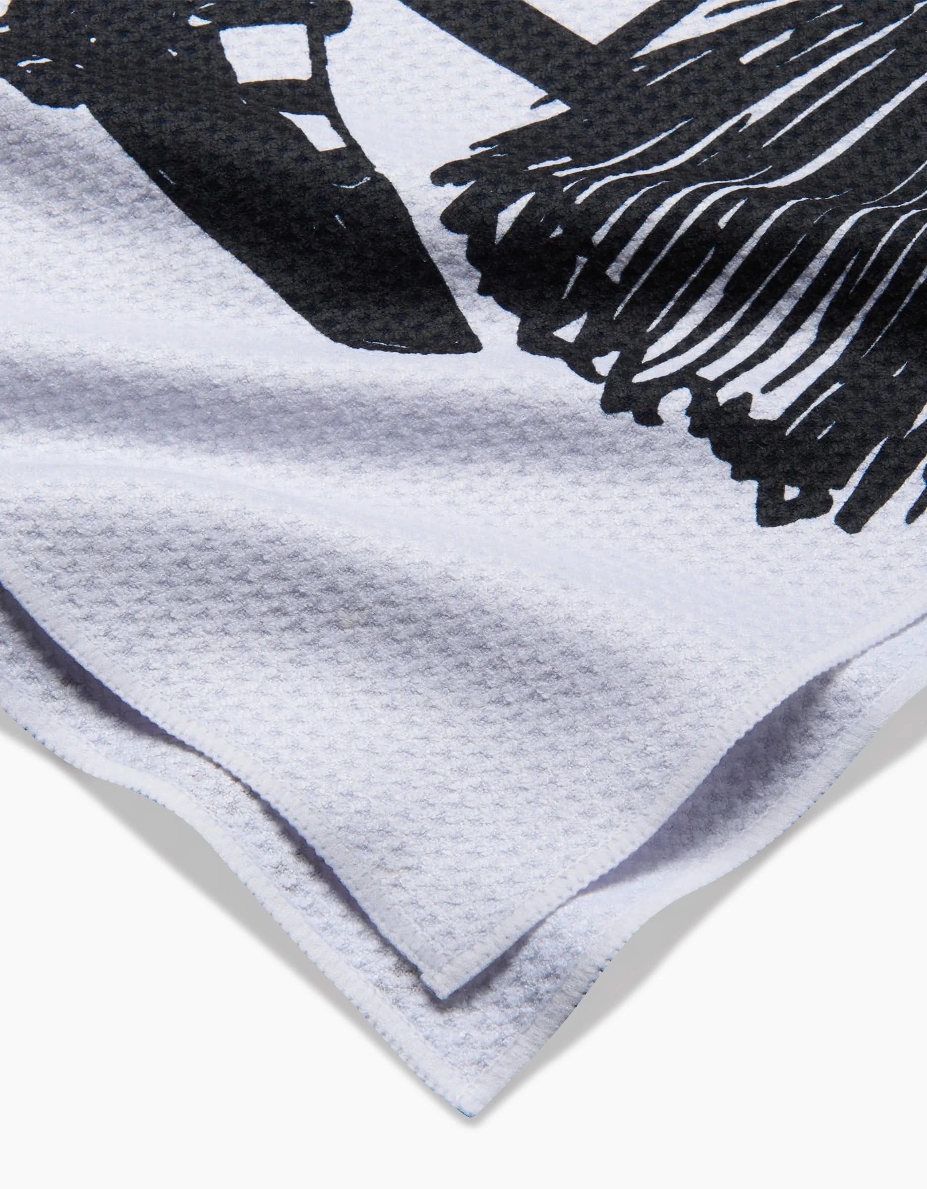Close-up of the Hufton Studio Halloween Witch Legs kitchen towel, featuring a white textured fabric with a black witch legs design and neatly folded corners.