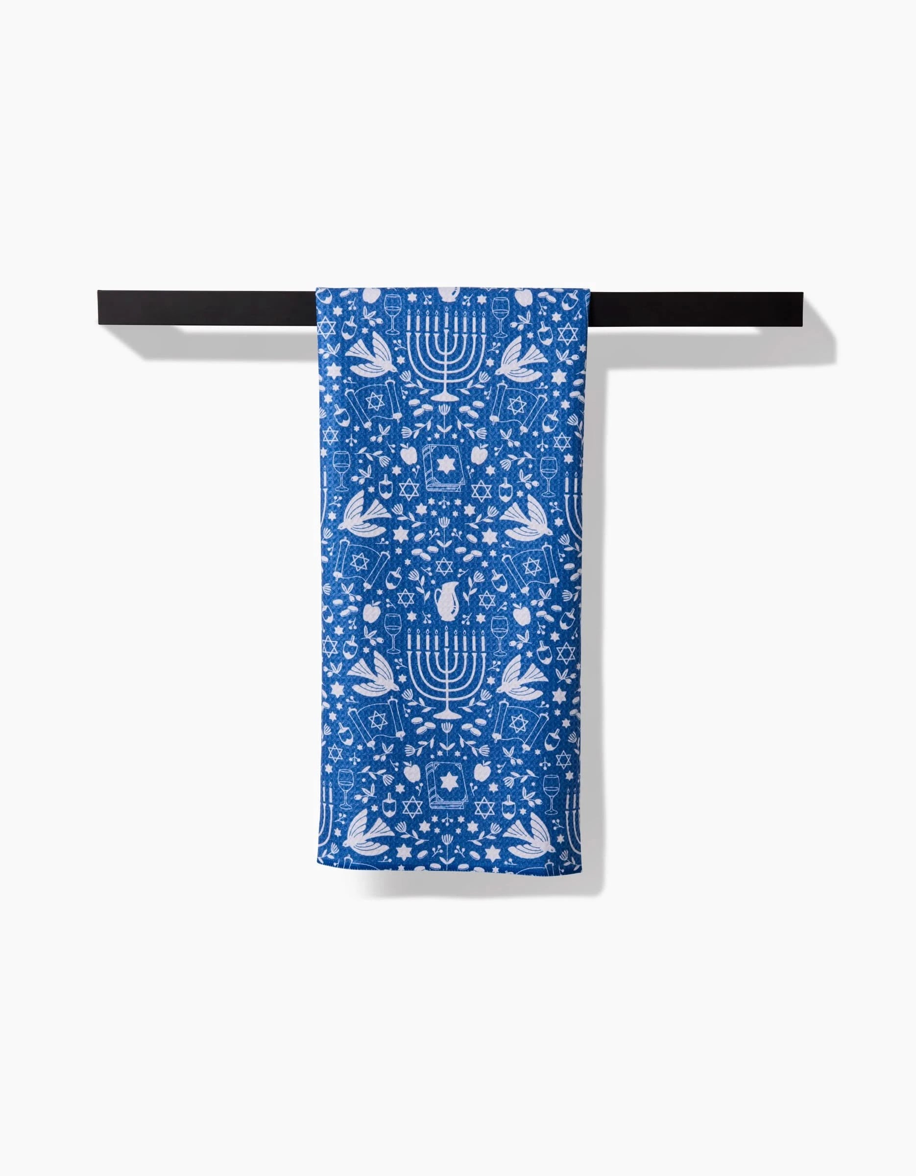 The Hanukkah Sameach tea towel by Megan Kampa features eco-friendly blue and white designs of menorahs, doves, Stars of David, and pomegranates—a charming, quick-drying kitchen towel for any home.
