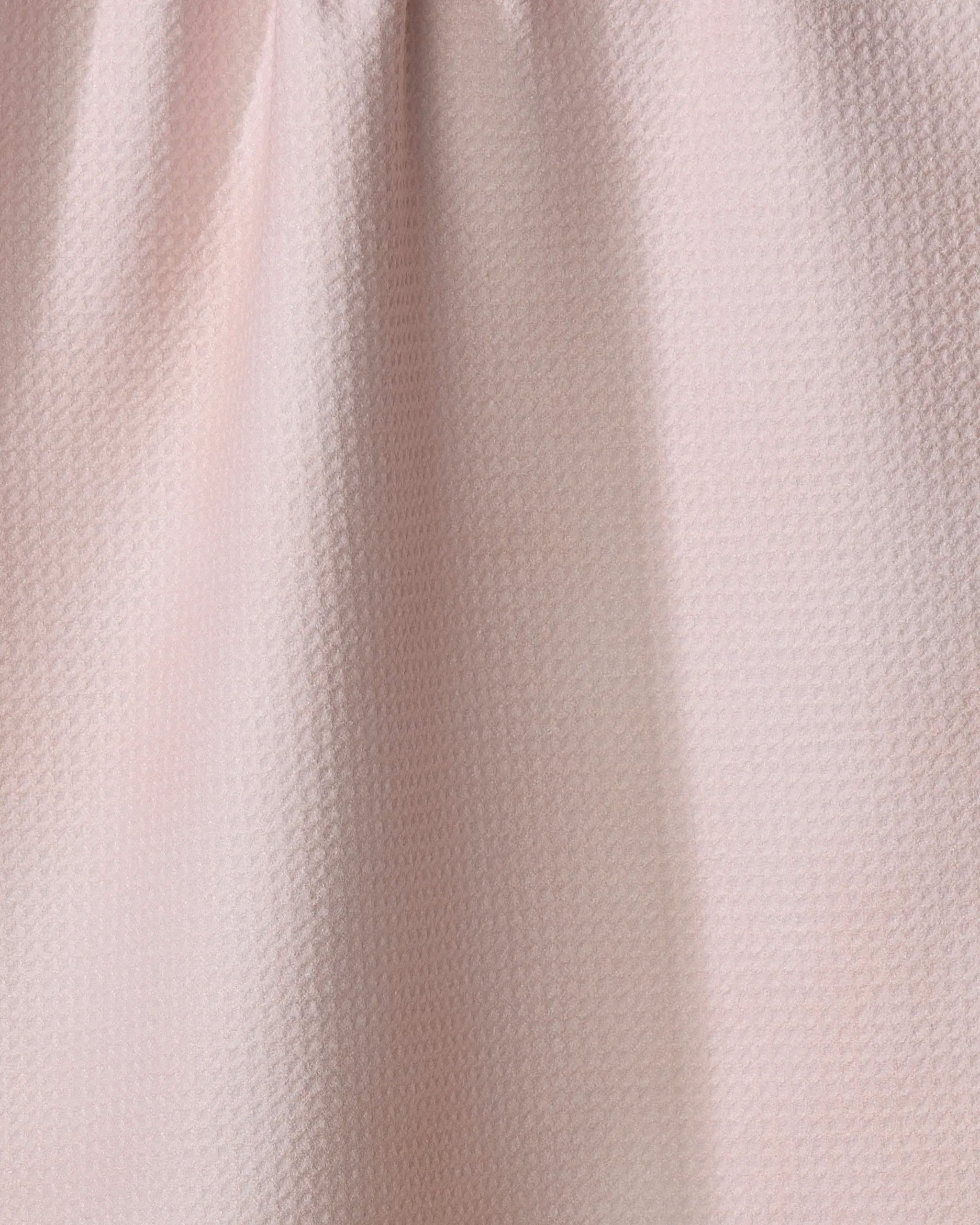 Close-up of the Harper Pink dish towel by Kailee Wright, featuring light pink textured fabric with a subtle pattern and gentle folds that highlight its soft, elegant, and absorbent qualities.