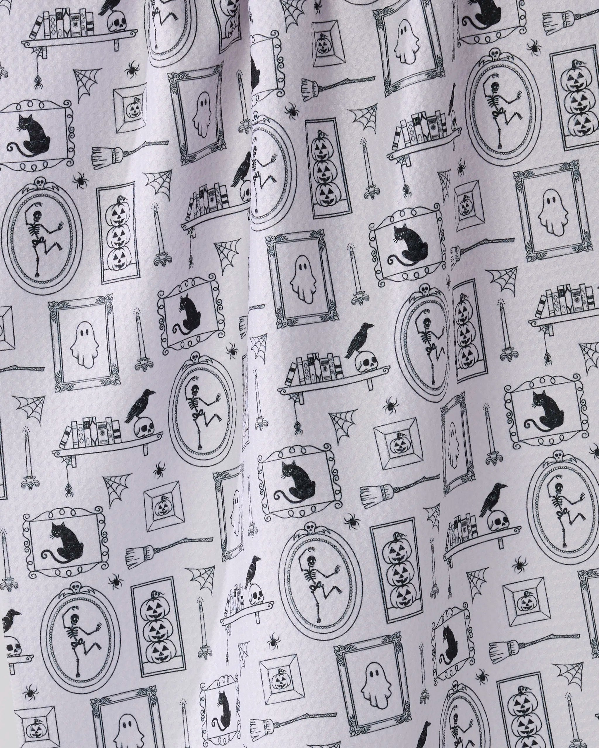 The Geometry "Haunted Gallery" white tea towel features a repeating pattern of Halloween-themed black line drawings and is made from quick-drying recycled materials.