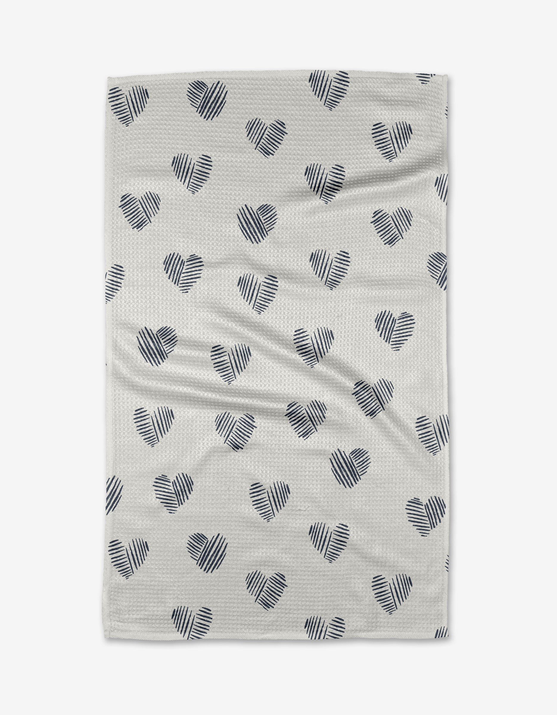 The Heartbreaker dish towel by Hufton Studio features a white absorbent fabric with a repeating pattern of black, diagonal line-drawn hearts evenly spaced across the surface, shown laid flat on a white background.