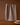 A Geometry Hearth tea towel with a brown and white checkered pattern hangs on a string against a brown background. A powdered sugar-dusted cake sits partially visible on a wooden table in the bottom right corner.