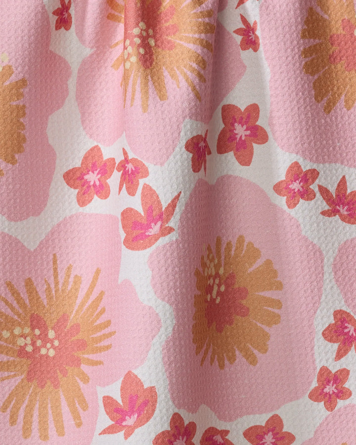 The Hibiscus Sunset tea towel by Janna Sue Design features large and small pink, orange, and yellow flowers on quilted pink and white fabric with raised texture—adding a charming touch to your kitchen.