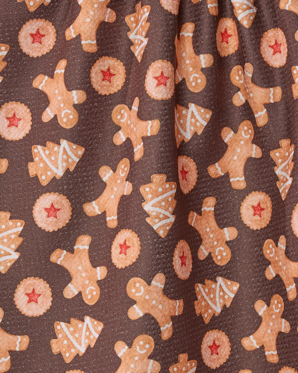 Geometry’s Holiday Cookies design features brown fabric adorned with cheerful gingerbread men, Christmas tree cookies decorated with white icing, and round cookies with festive red centers. This holiday-themed pattern is perfect for a Geometry recycled kitchen towel or tea towel, bringing seasonal joy and festive spirit to your kitchen.