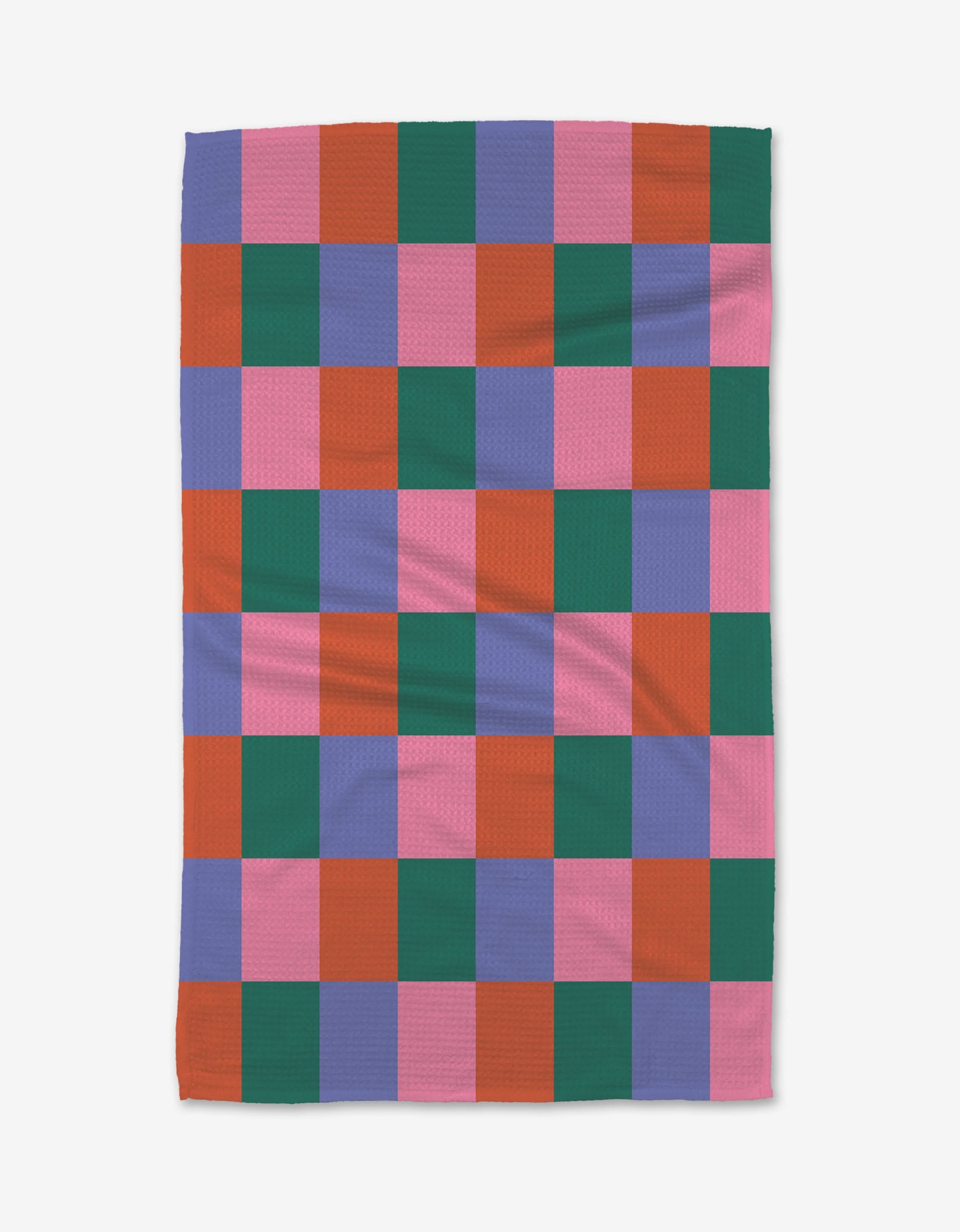 The Holiday Patchwork blanket by Laura Supnik features a checkerboard pattern with pink, red, green, and purple squares. Made from recycled materials, it is shown flat on a white background.