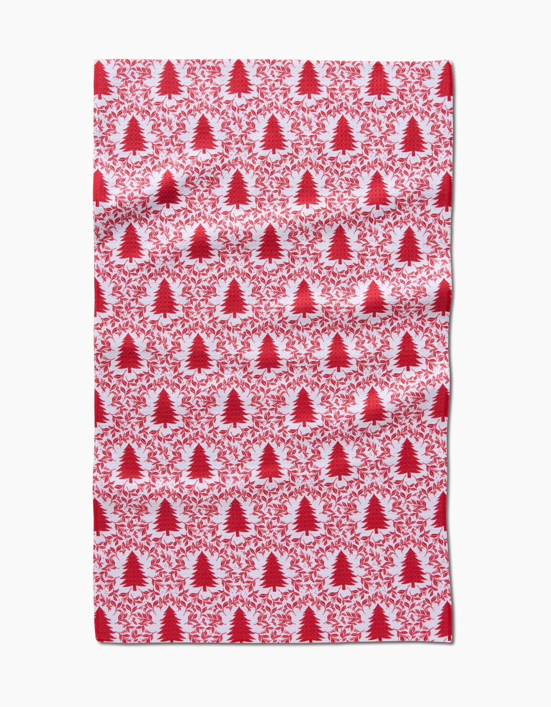 The Holiday Tree tea towel by Charlie Rowan Designs features a festive pattern of red Christmas trees and leafy branches on white, adding seasonal charm to your kitchen.