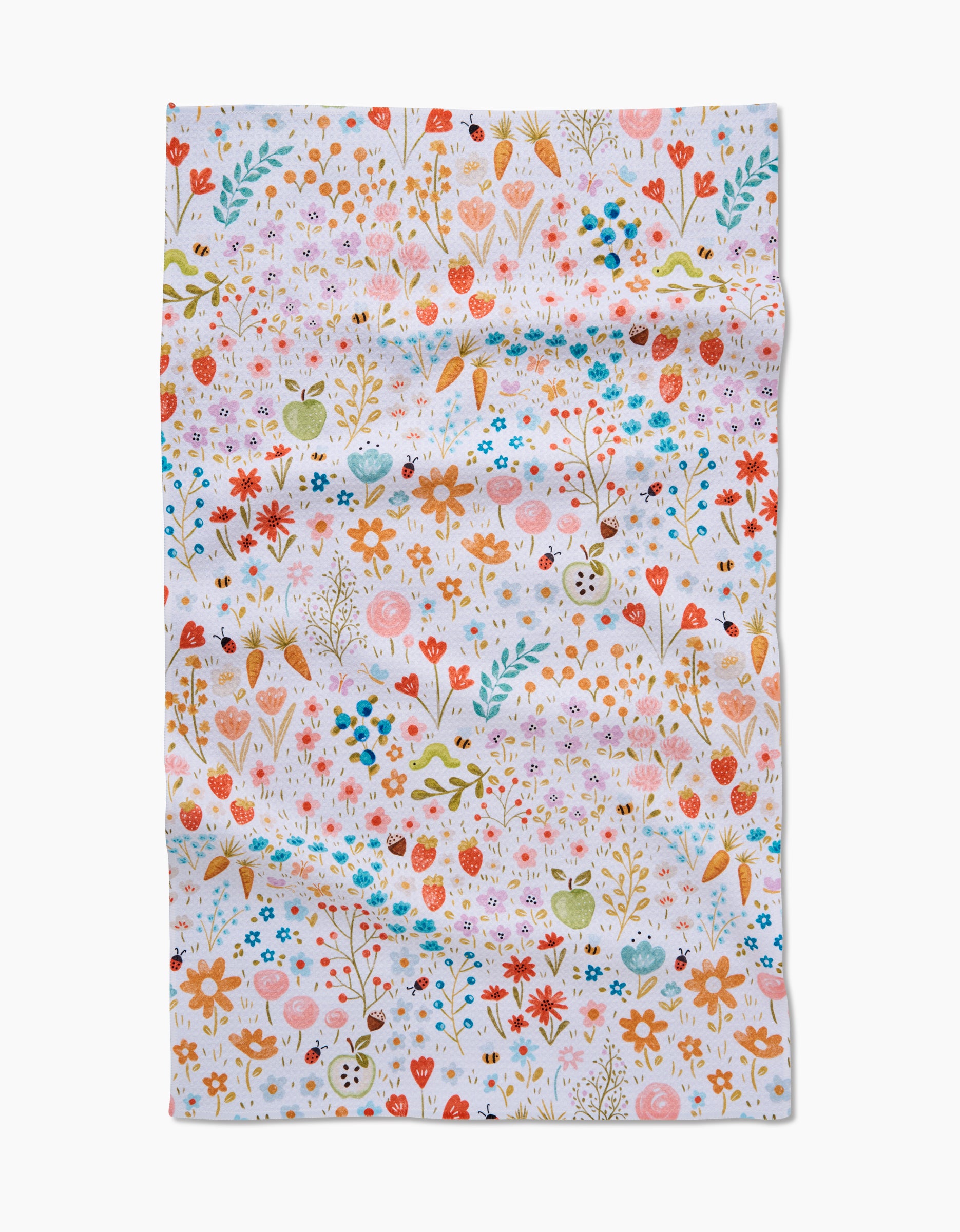 The Honeybee Heaven tea towel by Sara Mari is made from recycled materials and features a whimsical floral pattern with apples, berries, and leaves in red, orange, pink, green, and blue on white fabric with a slightly wrinkled texture.