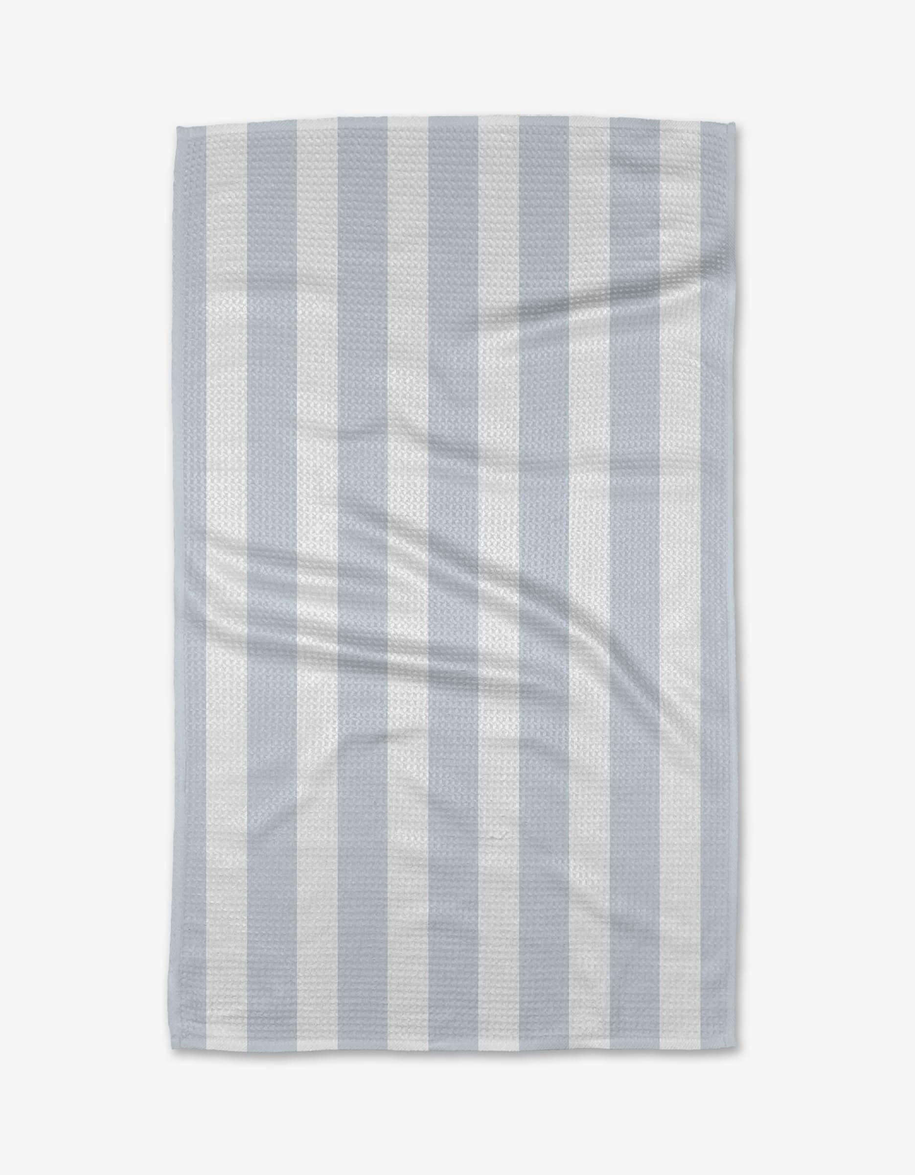 The BetterDays Hormones Tea Towel, featuring light blue and white vertical stripes with a waffle texture, is laid flat on a white background. Made from Geoweave™ fabric, it displays a slight wrinkle for added texture.