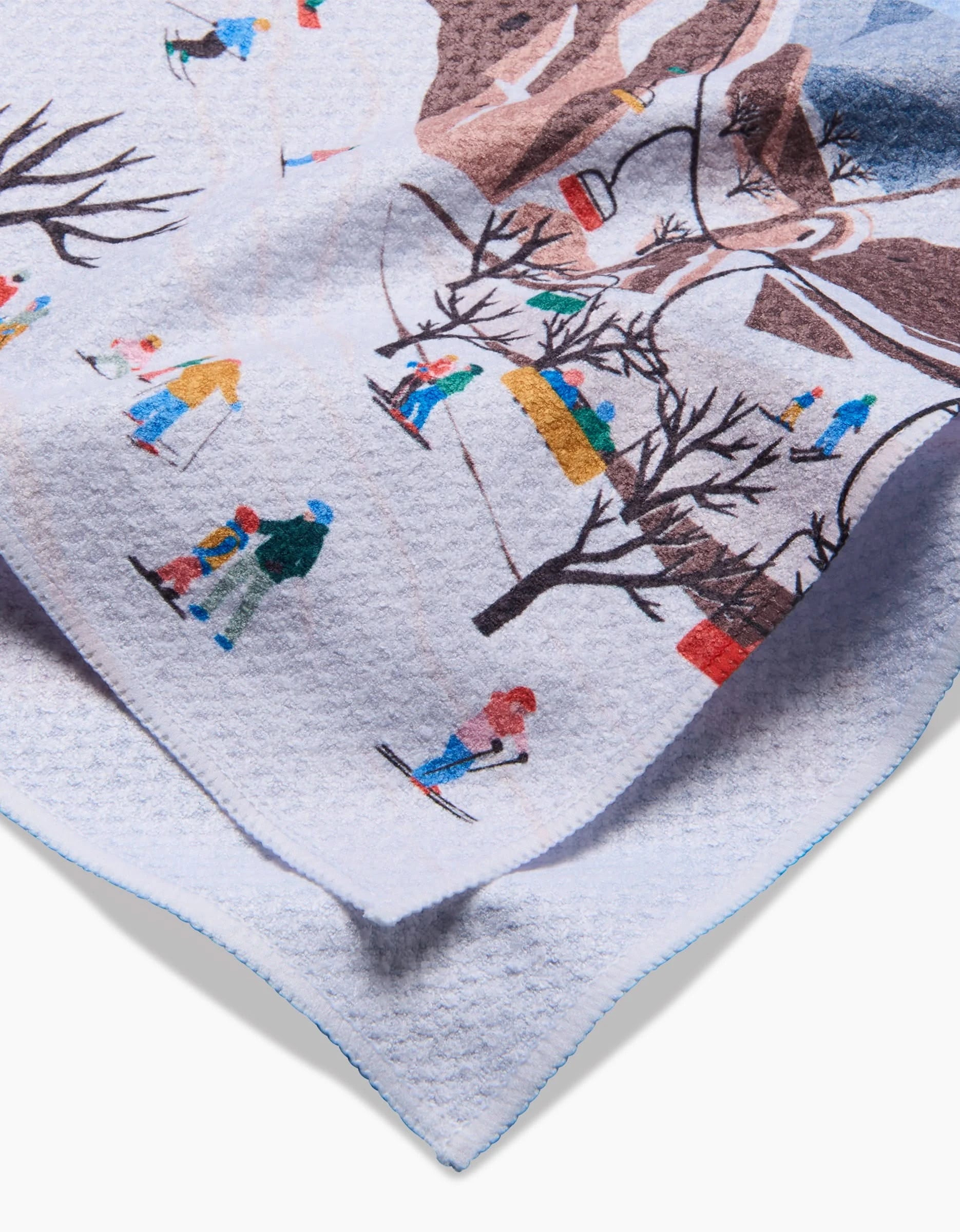 A close-up of a Ceyda Alasar kitchen towel named Hot Air Balloons, crafted from recycled materials, featuring an illustrated scene with hot air balloons among clouds and trees, with a textured surface and light blue edge stitching.