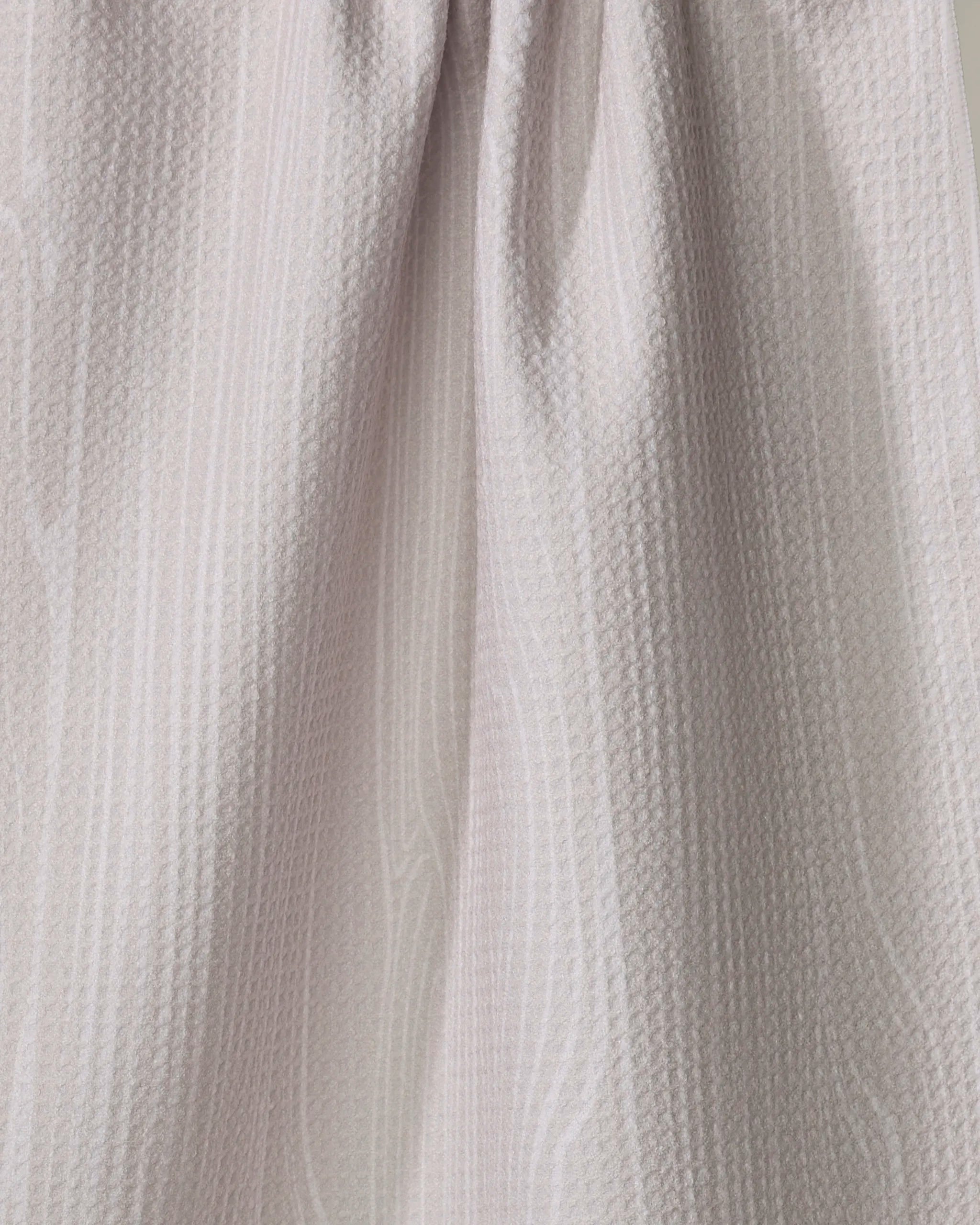 Close-up of the Houston Wood tea towel by Kailee Wright, in light beige, quick-drying, made from recycled materials with a subtle wavy pattern and soft draping folds.