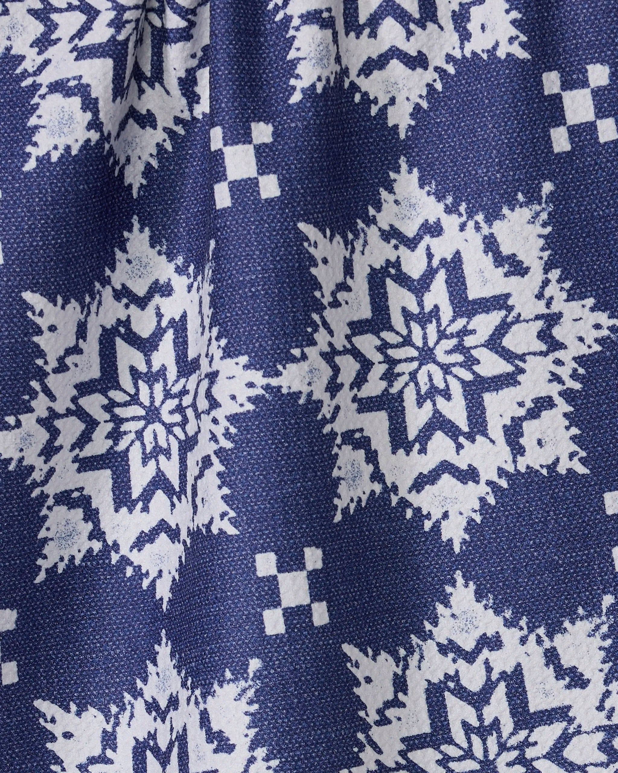 The Geometry Iceflower Blue kitchen towel features a blue fabric with a repeating white geometric snowflake pattern and small squares, a textured surface with slight folds, and is made from recycled materials—perfect for adding charm to your kitchen.