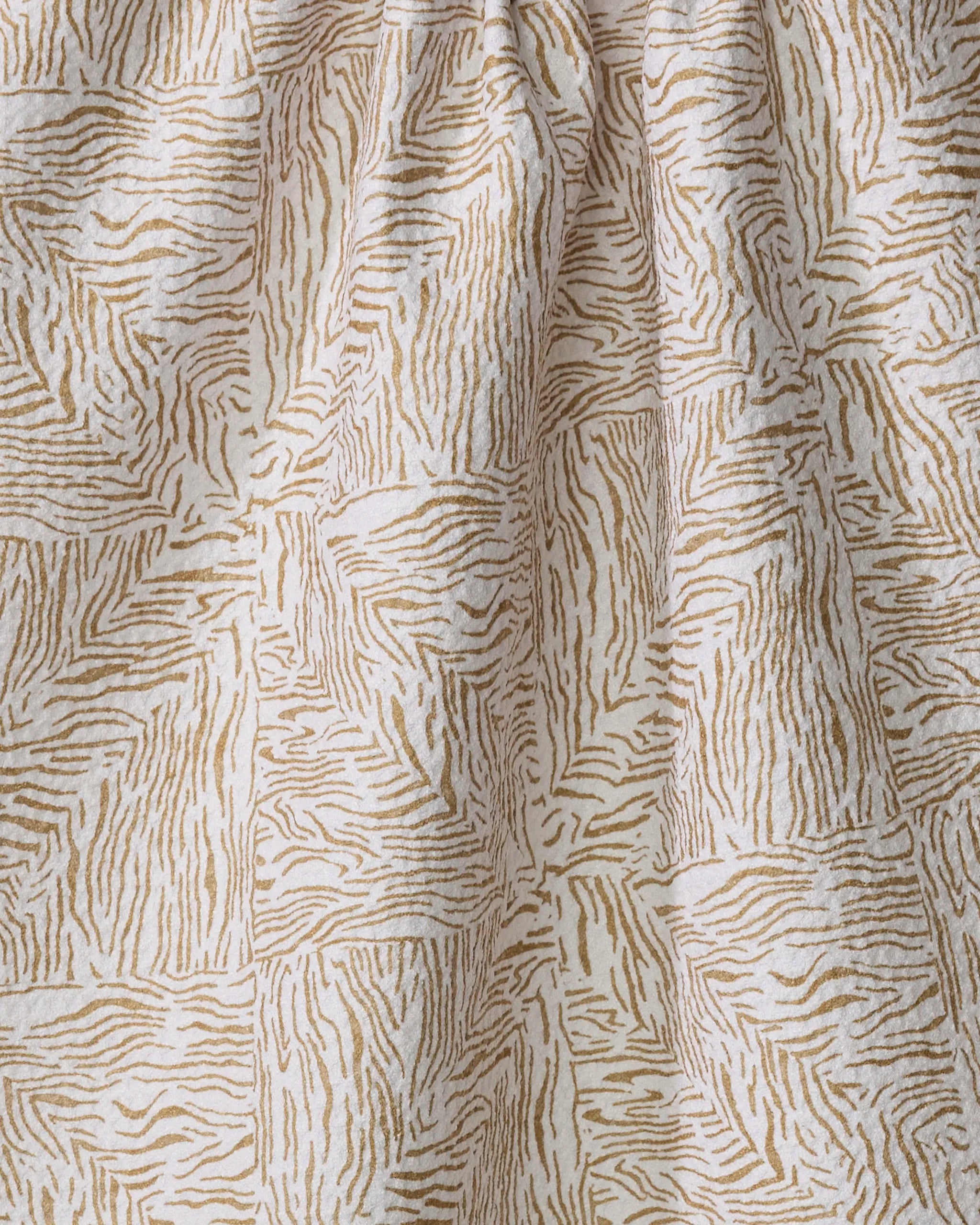 Studio Jeannot’s Inlay kitchen towel features beige recycled fabric with an abstract zebra-like stripe pattern in light brown and white, soft texture, gentle folds, and subtle shadows.