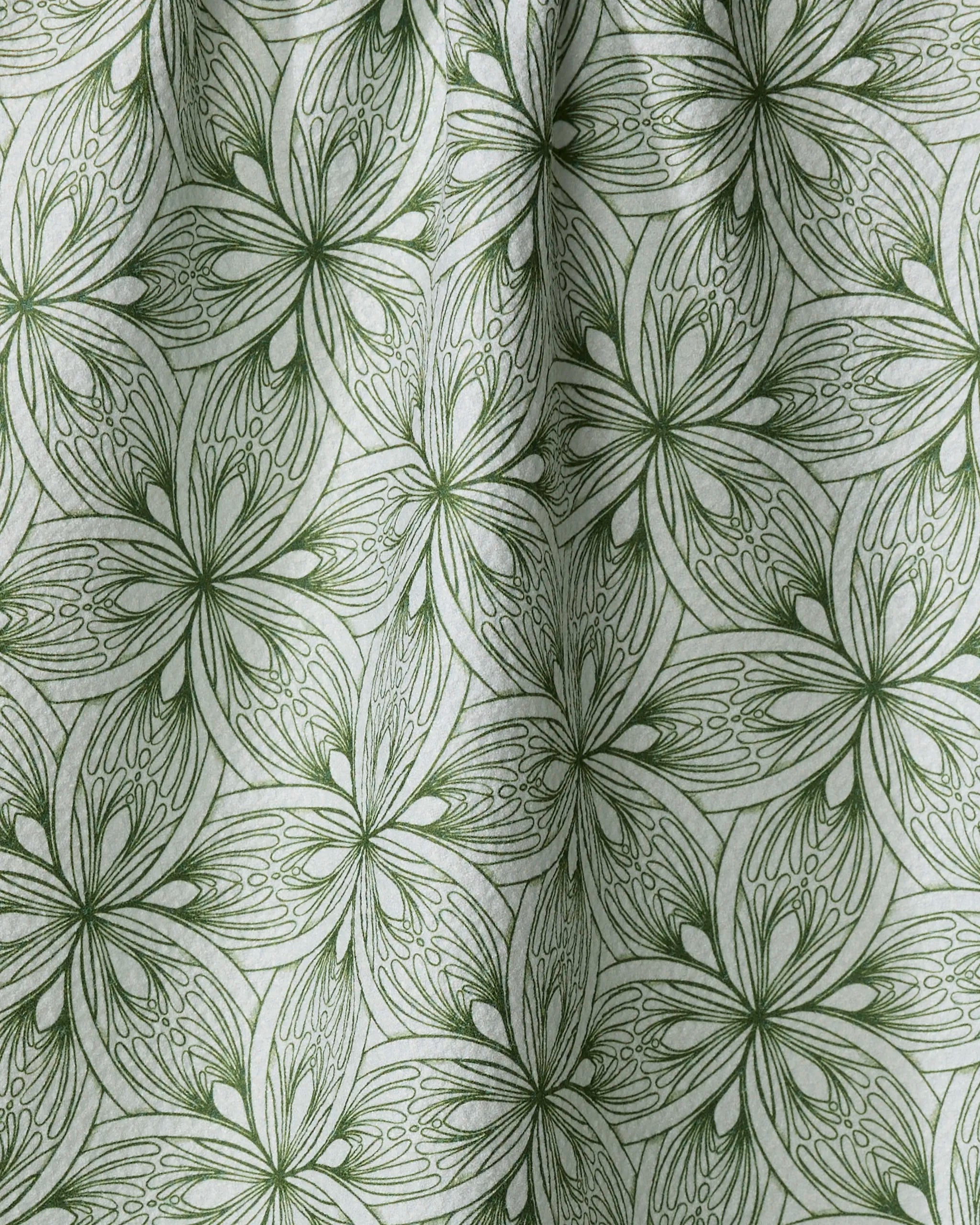 Interlaced Petals by Marta Harvey is a green and white quick-drying towel with a pattern of stylized, overlapping flowers and leaves. Fine lines and gentle folds create subtle shadows, adding textured detail to the fabric.