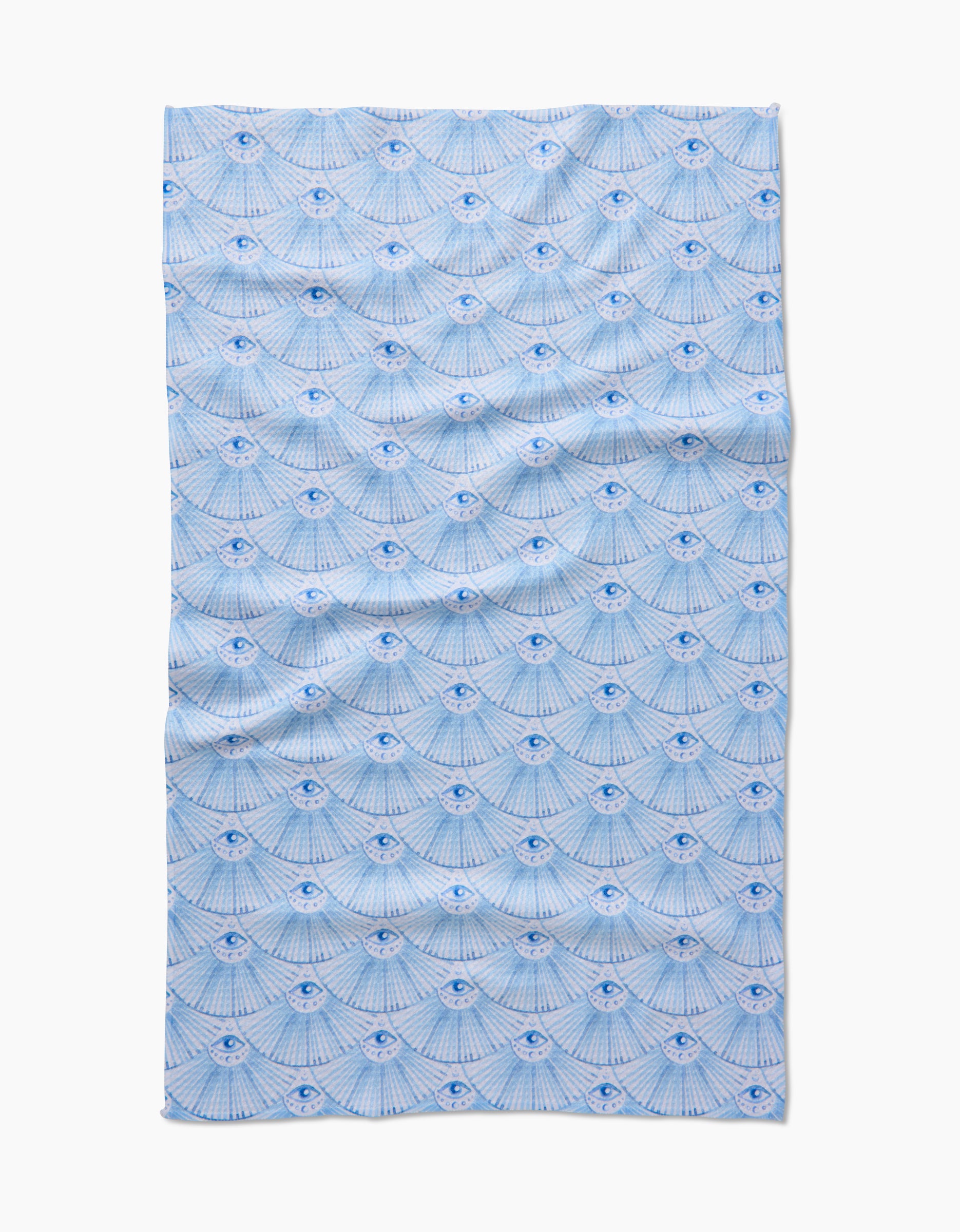 Into The Mystic by Maayan Alper-Swan is a blue and white tea towel made from post-consumer recycled materials, featuring rows of stylized eyes with radiating lines. The textile lies flat with some visible creases.