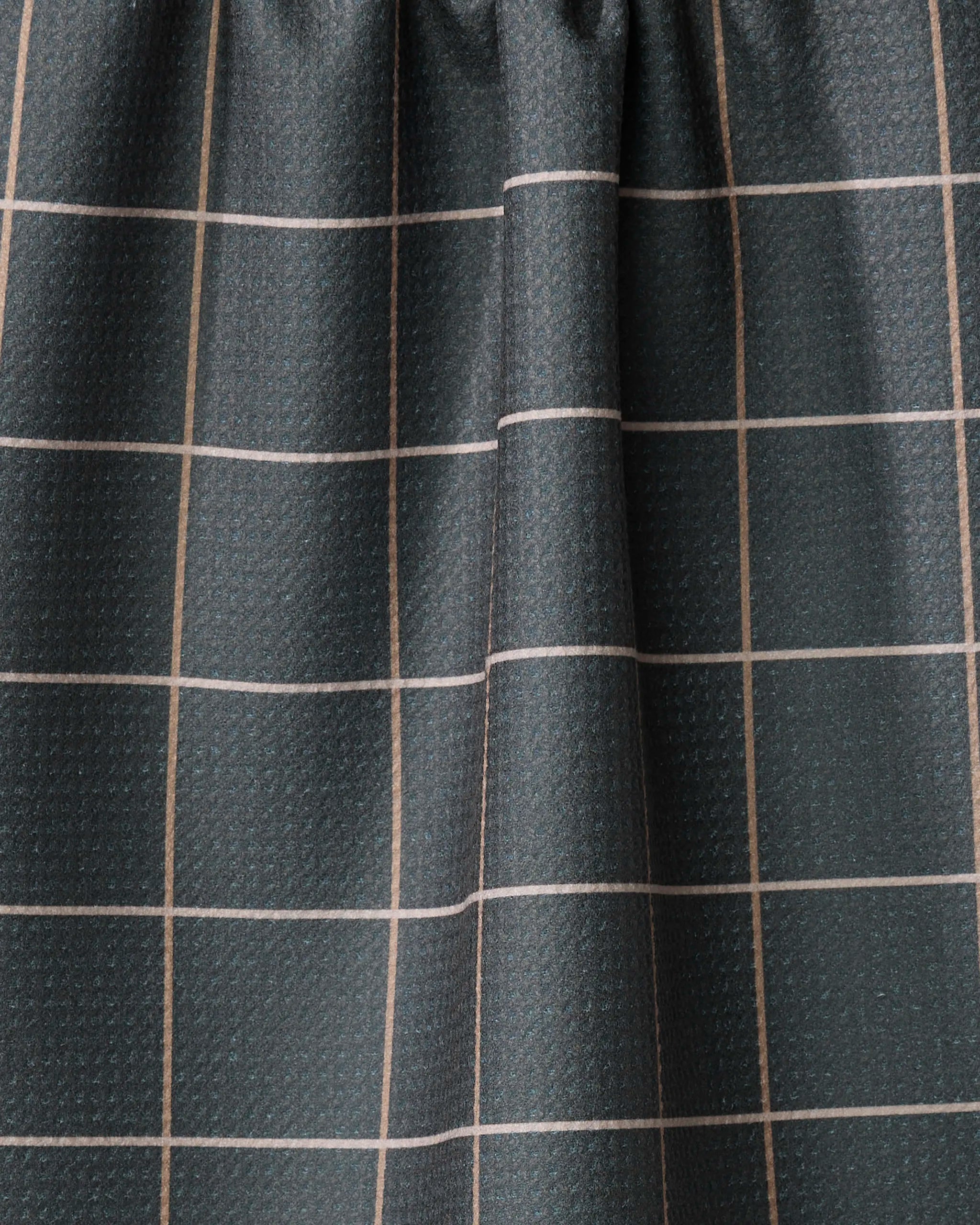 A close-up of Iron Grid by Kelsi Fullmer shows dark, textured fabric with a grid of thin, light lines gathered in soft folds—ideal for creating a stylish, recycled-material kitchen towel.