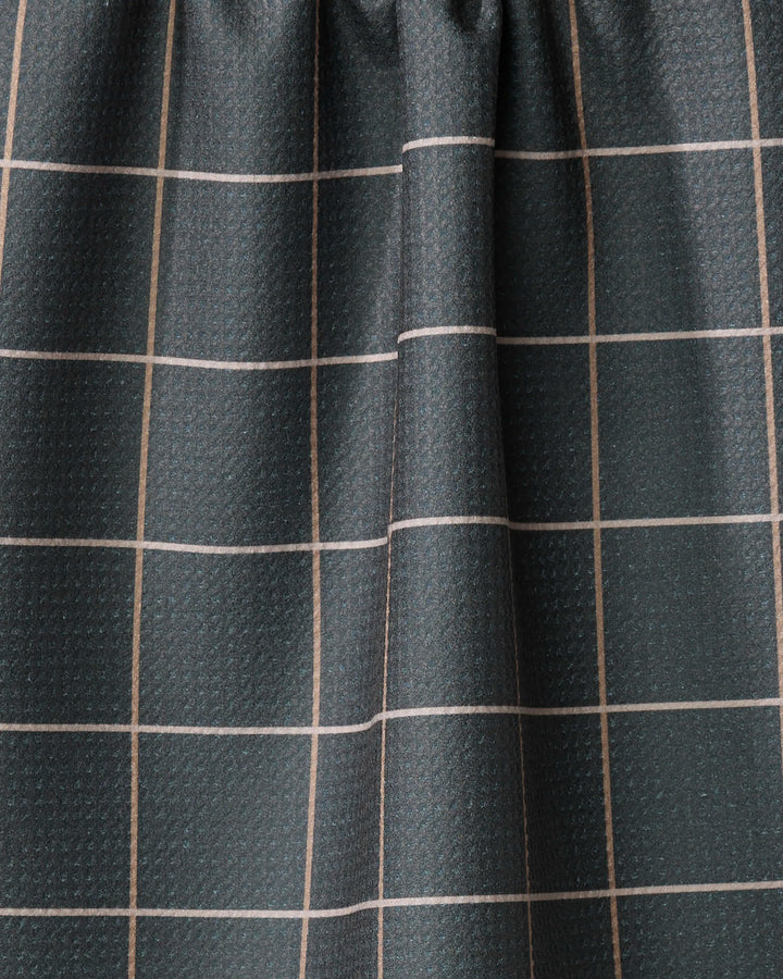 A close-up of Iron Grid by Kelsi Fullmer shows dark, textured fabric with a grid of thin, light lines gathered in soft folds—ideal for creating a stylish, recycled-material kitchen towel.