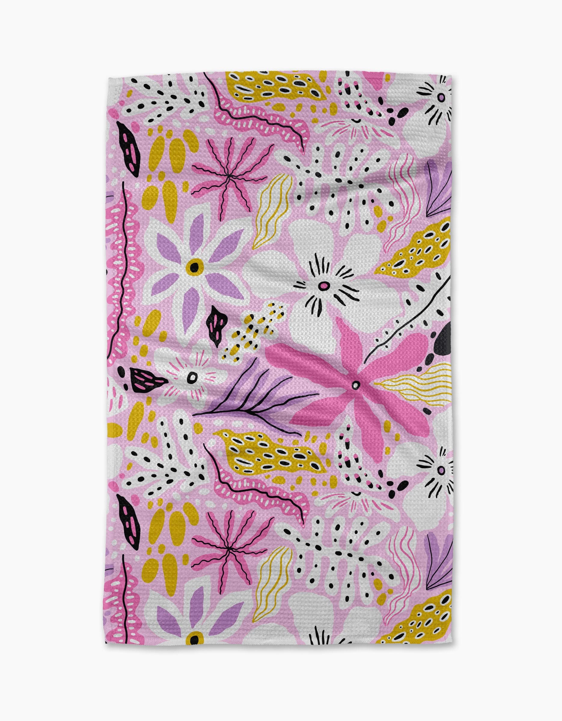 Island Time by Marina Solodka is a rectangular white tea towel with a lively abstract floral pattern, featuring pink, purple, yellow, and black shapes in a whimsical design.