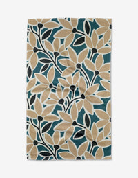 The Janine towel by Amy MacCready features a bold botanical pattern with beige, dark green, and black leaves on white Geoweave fabric, giving it a textured, slightly wrinkled, and eco-friendly appearance.