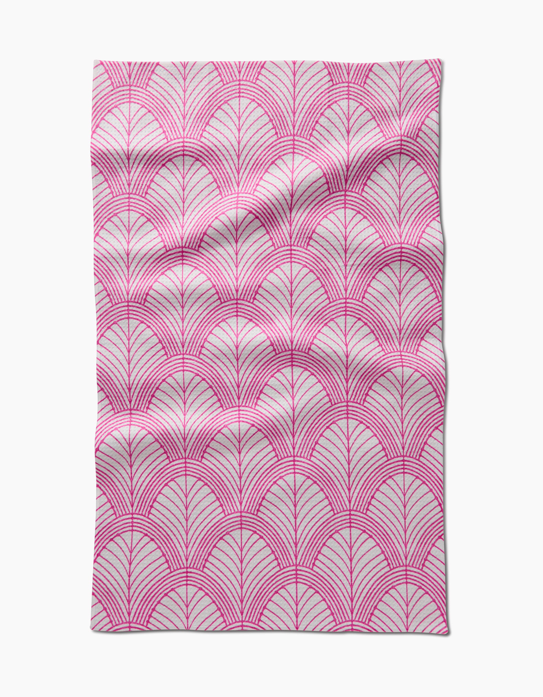 The Amy MacCready Jaskin tea towel is rectangular, made from Geoweave fabric, and features a pink geometric pattern of overlapping semi-circles and radiating lines on a white background, with subtle creases and folds.