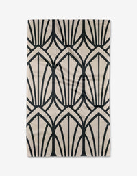 The Jocelyn rug by Amy MacCready is a rectangular beige piece with bold black art deco fans and arches, laid flat on a white background and crafted from recycled materials for eco-friendly style.