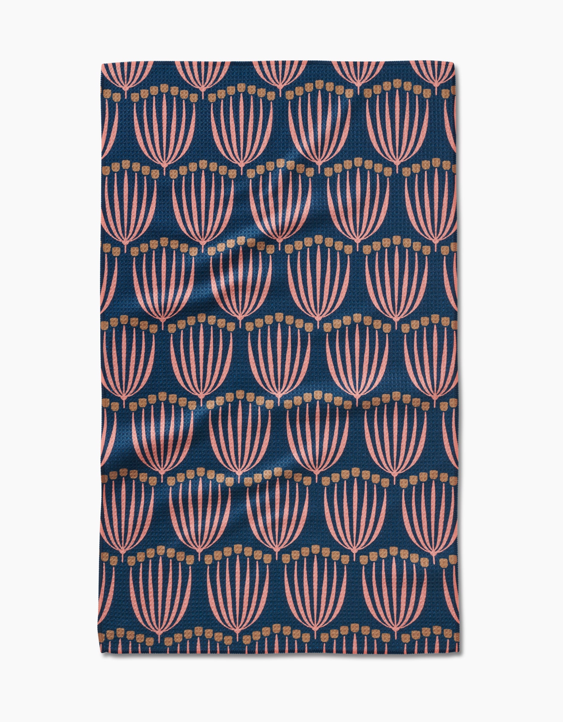 The Josie Geoweave™ tea towel by Amy MacCready features pink and gold stylized floral shapes on a dark blue background. Ultra-absorbent and beautifully designed, its the perfect modern kitchen accessory.