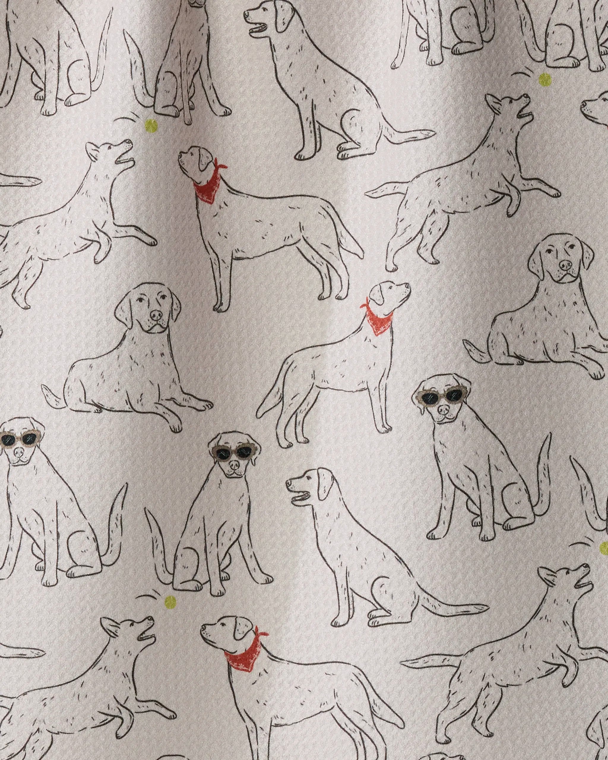 The Lab Pack kitchen towel by Geometry features line drawings of dogs—some sporting red collars and others with sunglasses—printed on a light, textured background and crafted from recycled materials.