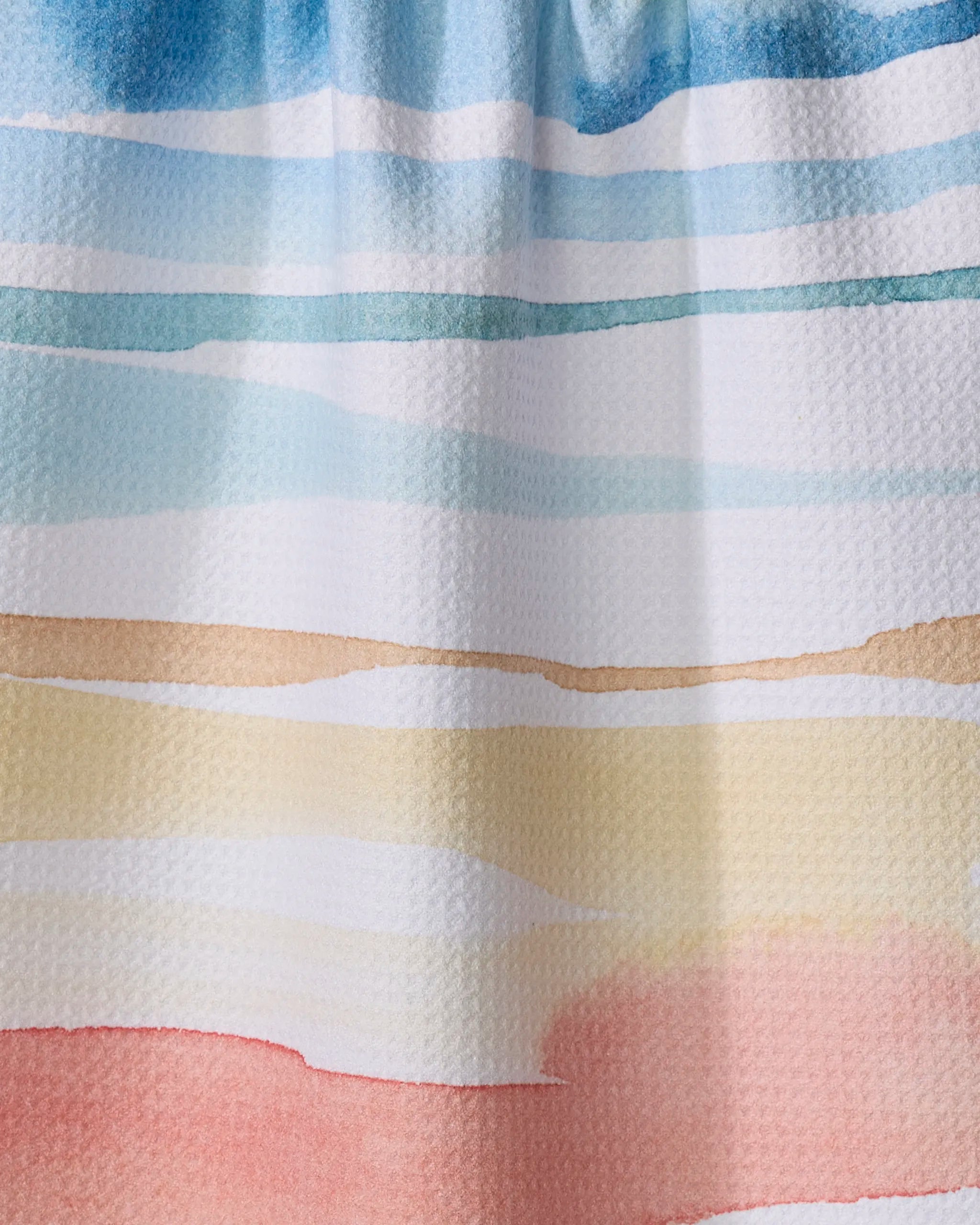 Sara Mari's Lakeside towel features abstract watercolor bands in soft blue, teal, beige, yellow, and pink on a textured surface. The serene, beach-inspired palette is perfect for this ultra-absorbent design.