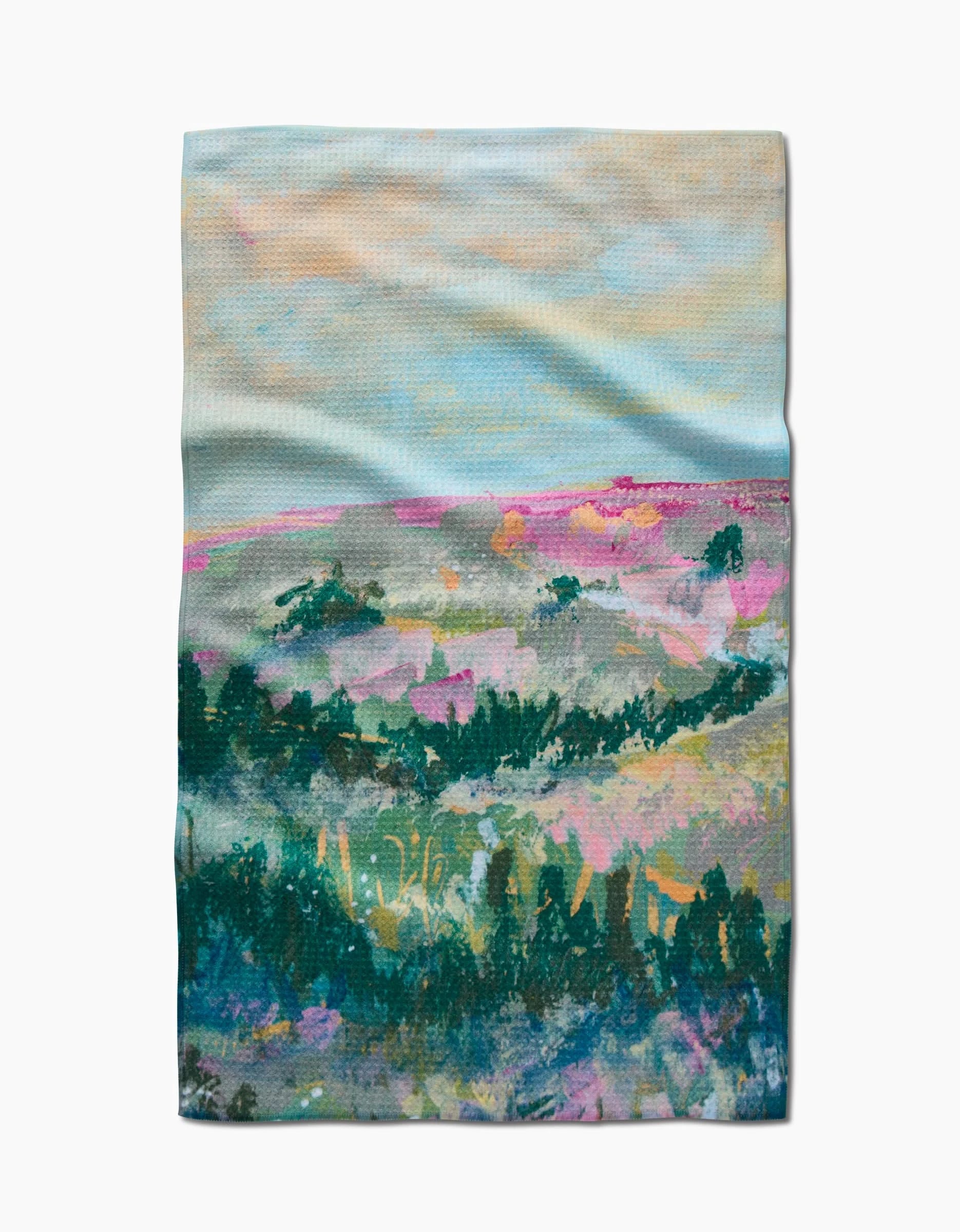 The Land of Milk and Honey Kitchen Tea Towel by Taryn Brennan features a dreamy, impressionist-style landscape in soft blue, pink, green, and purple on Geoweave fabric for a textured, abstract effect.
