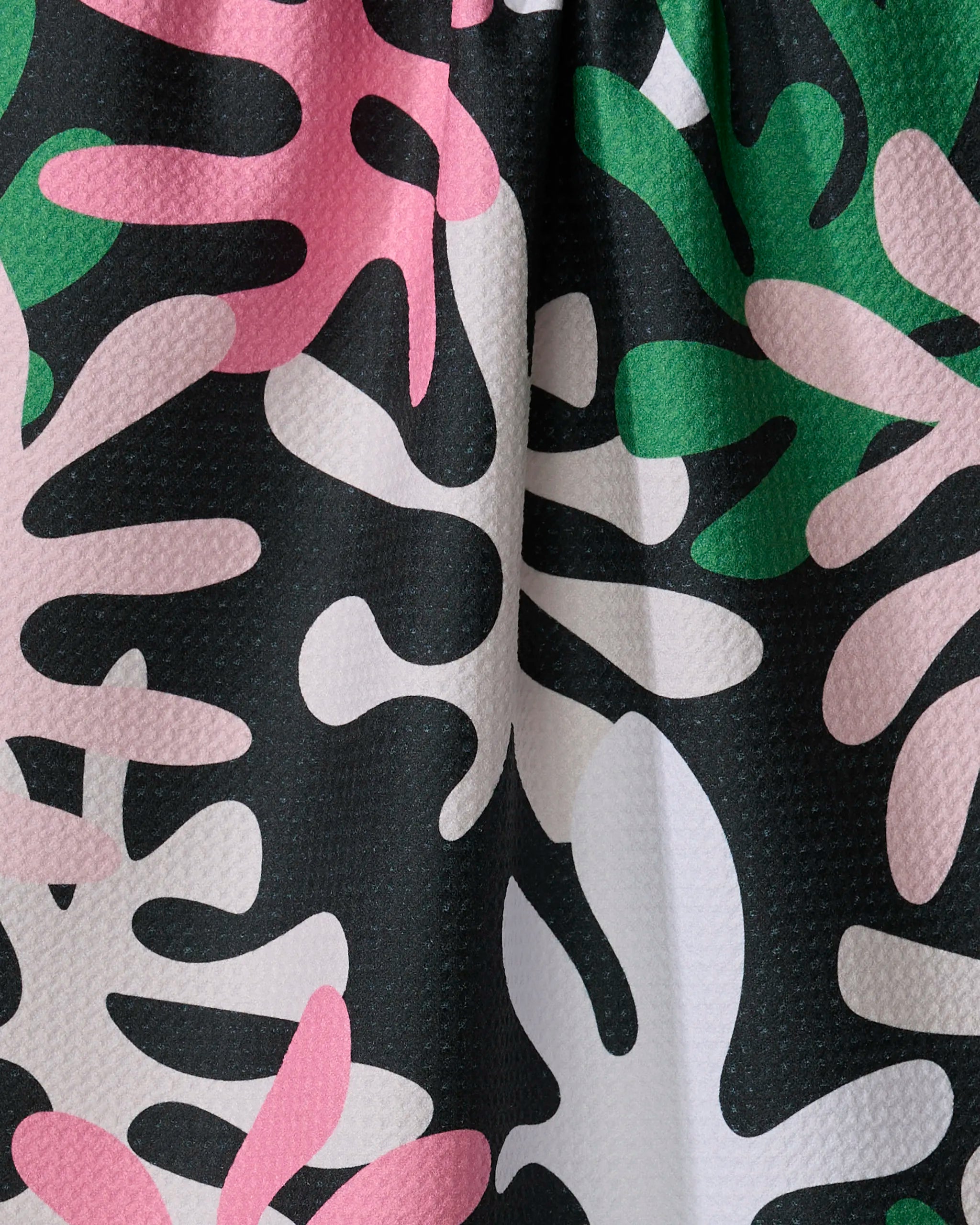 Late Night by Marina Solodka: a bold kitchen towel with a modern abstract pattern of overlapping organic shapes in pink, green, white, and black. Made from recycled materials with curved and irregular forms.