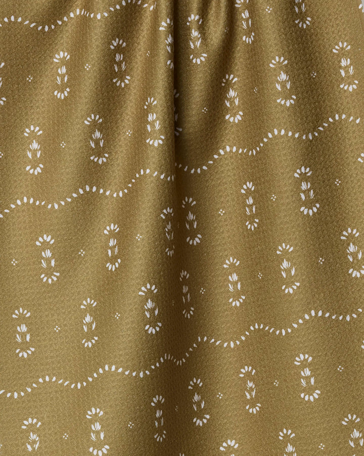 Close-up of the Laurel tea towel by Melissa Johnson, featuring a light brown color with small white floral and dotted patterns in wavy lines. The slightly gathered fabric is crafted from recycled materials.
