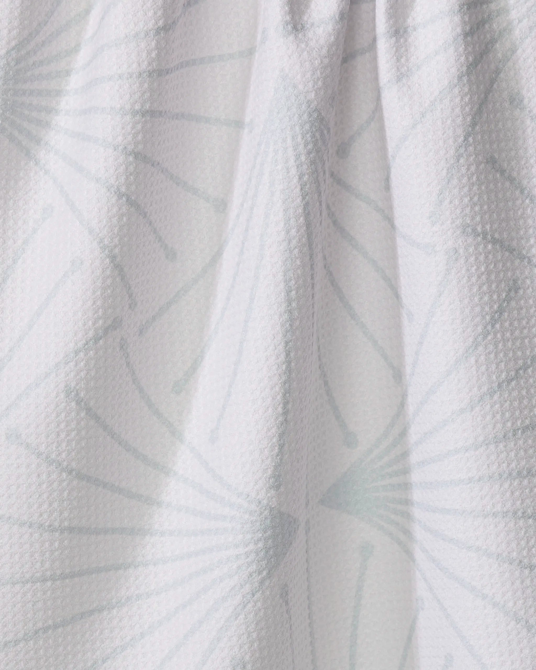 Close-up of Libby Cream by Amy MacCready: a white, textured fabric from recycled materials featuring a subtle light gray geometric pattern of fan-like radiating lines and small dots, with a slightly gathered appearance.