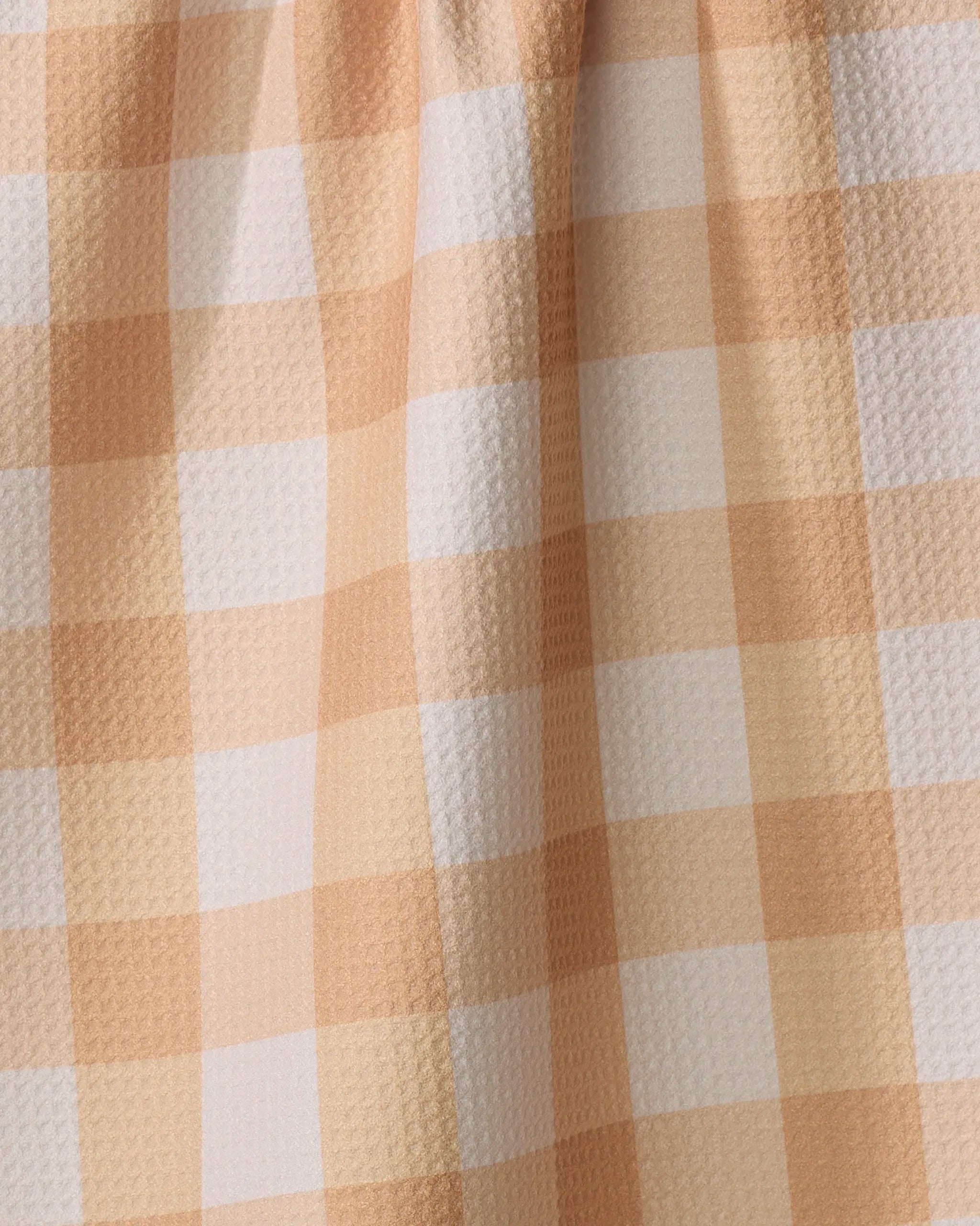 Close-up of the Lorraine fabric by Kelsi Fullmer, featuring a peach and white gingham check with a textured surface and soft folds—perfect for an eco-friendly kitchen tea towel.