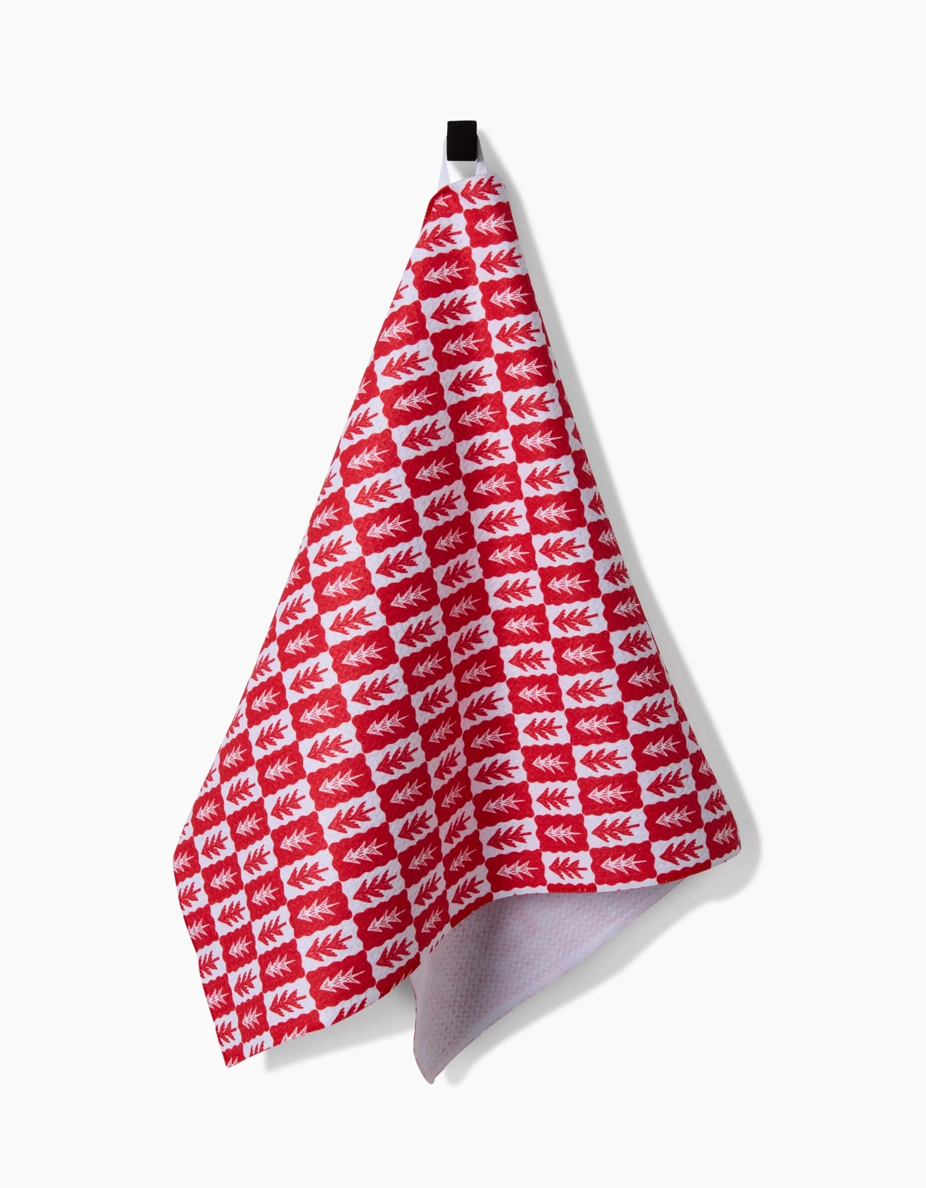 The Louis Pines tea towel by Roxy Marj features a red and white checkered, ultra-absorbent design with a leaf pattern, hanging from a black loop against a plain white background.