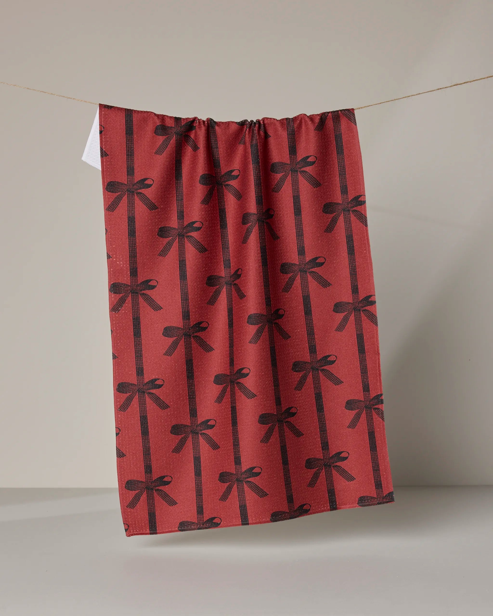 The Geometry Love Bows towel is a red, ultra-absorbent kitchen tea towel featuring stylish bow designs.