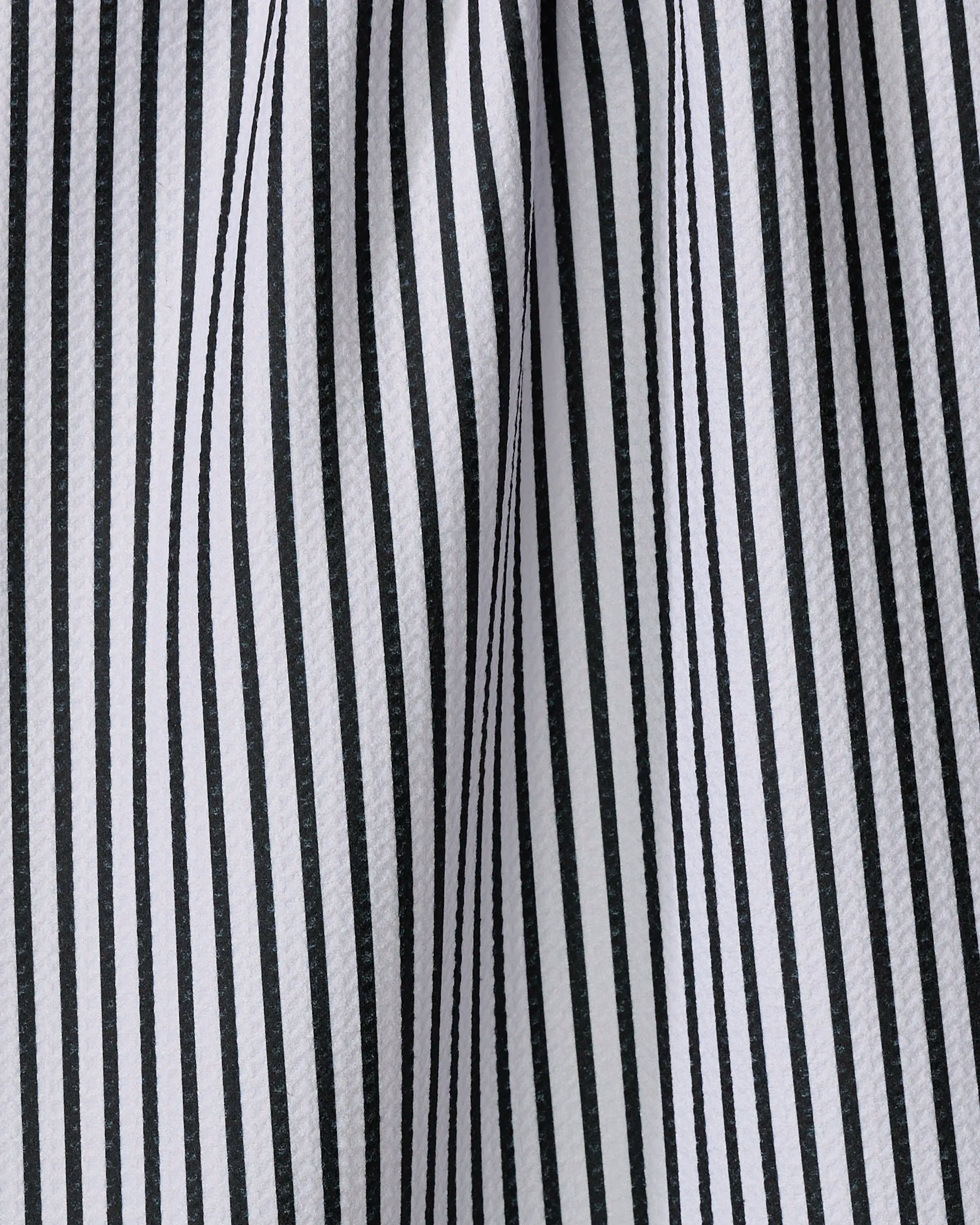 Close-up of the Love Notes tea towel by Kailee Wright, featuring black and white vertical stripes. Made from recycled materials, the fabric is gently draped, creating soft folds and shadows between the stripes.